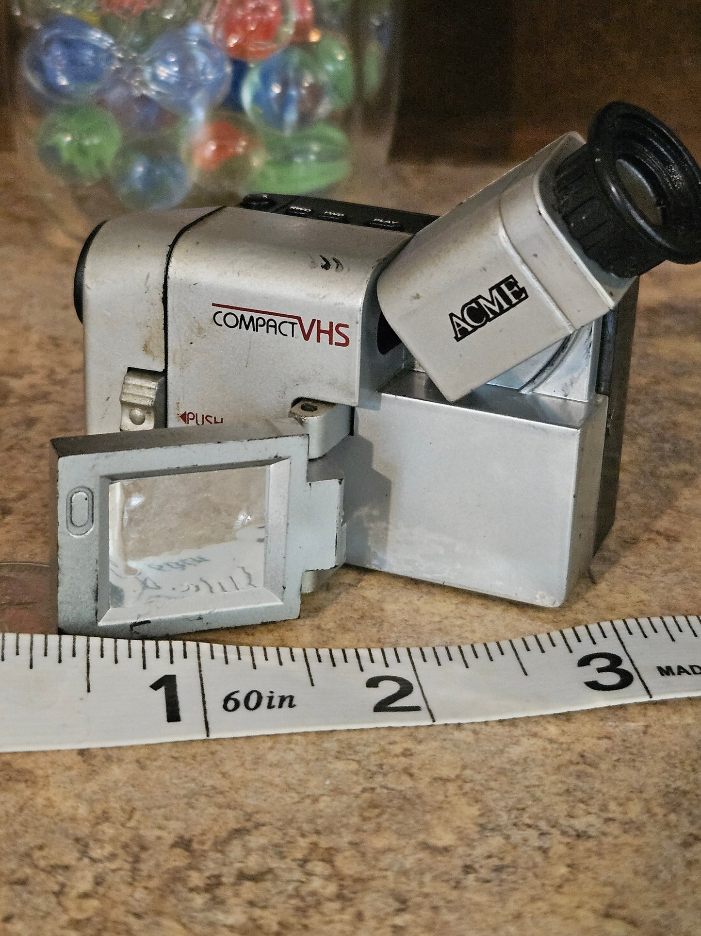 ACME miniature camcorder with flip-open LCD panel open revealing Smile You're on Candid Camera message