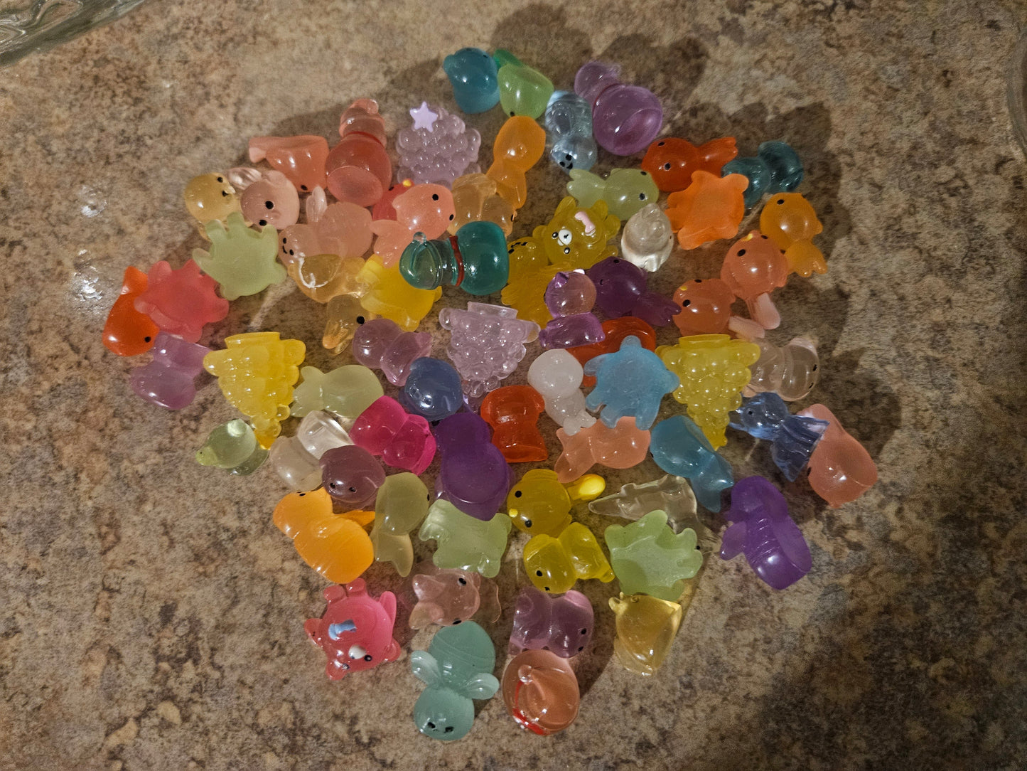 Approximately 50 mixed resin animal figurines spread out showing variety of shapes and colors