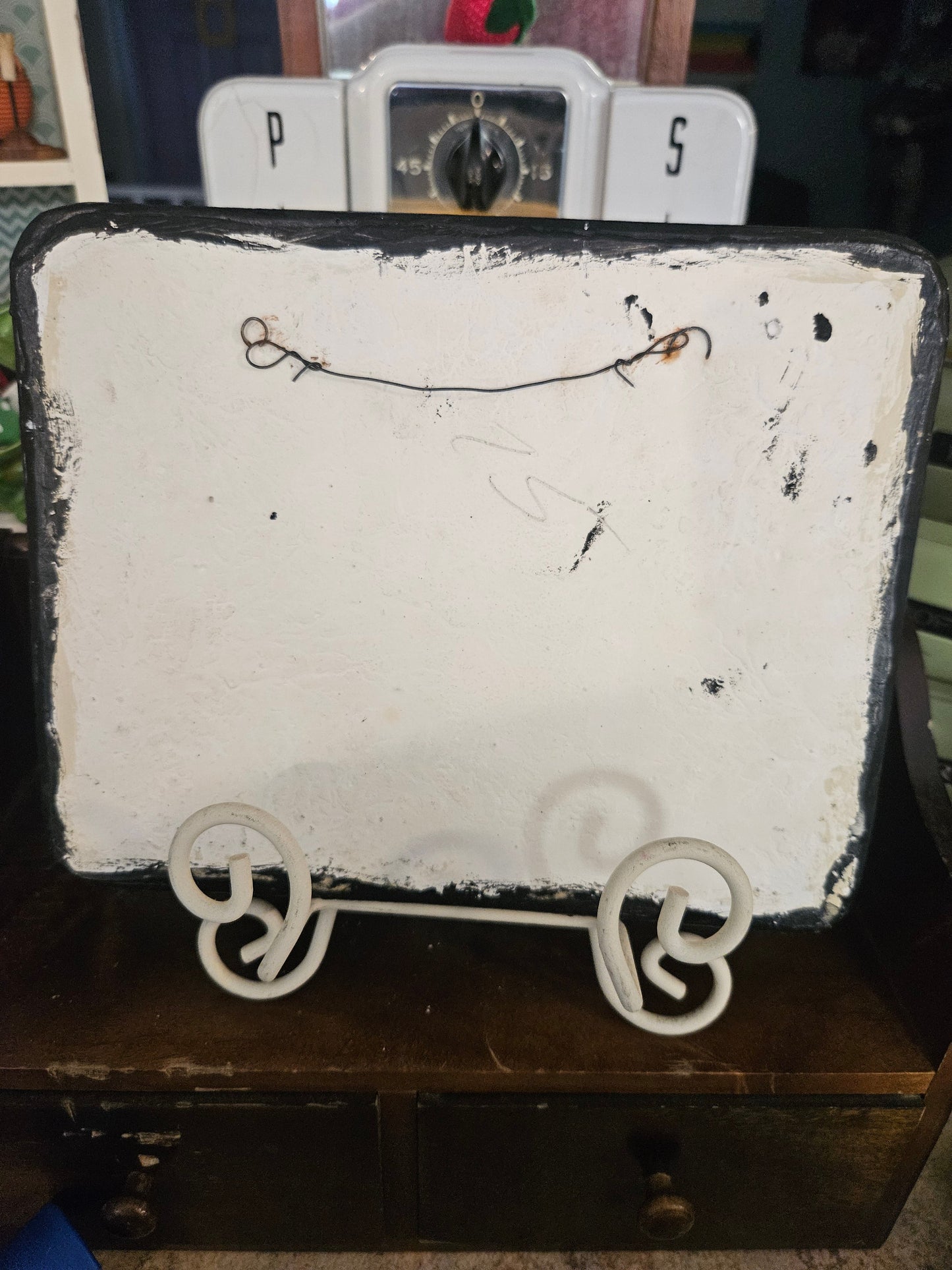 Back of vintage ceramic fishing plaque showing wire hanger and paint loss on reverse
