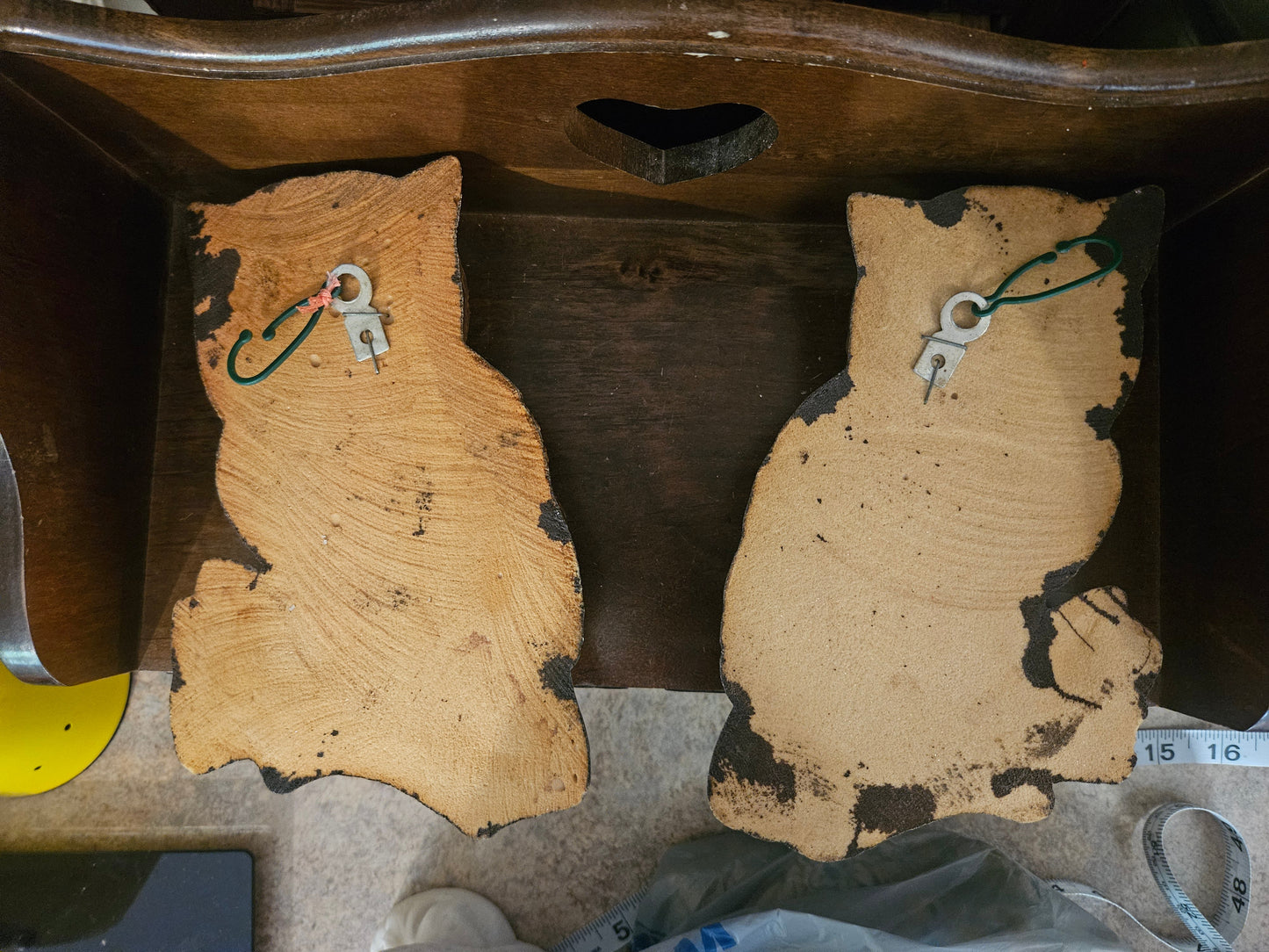 Back of vintage chalkware owl wall hangings showing raw cork composite backing and sawtooth hangers