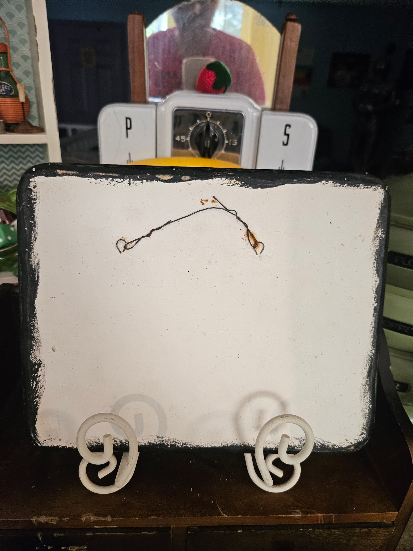 Back of vintage ceramic novelty plaque showing wire hanger and white painted reverse