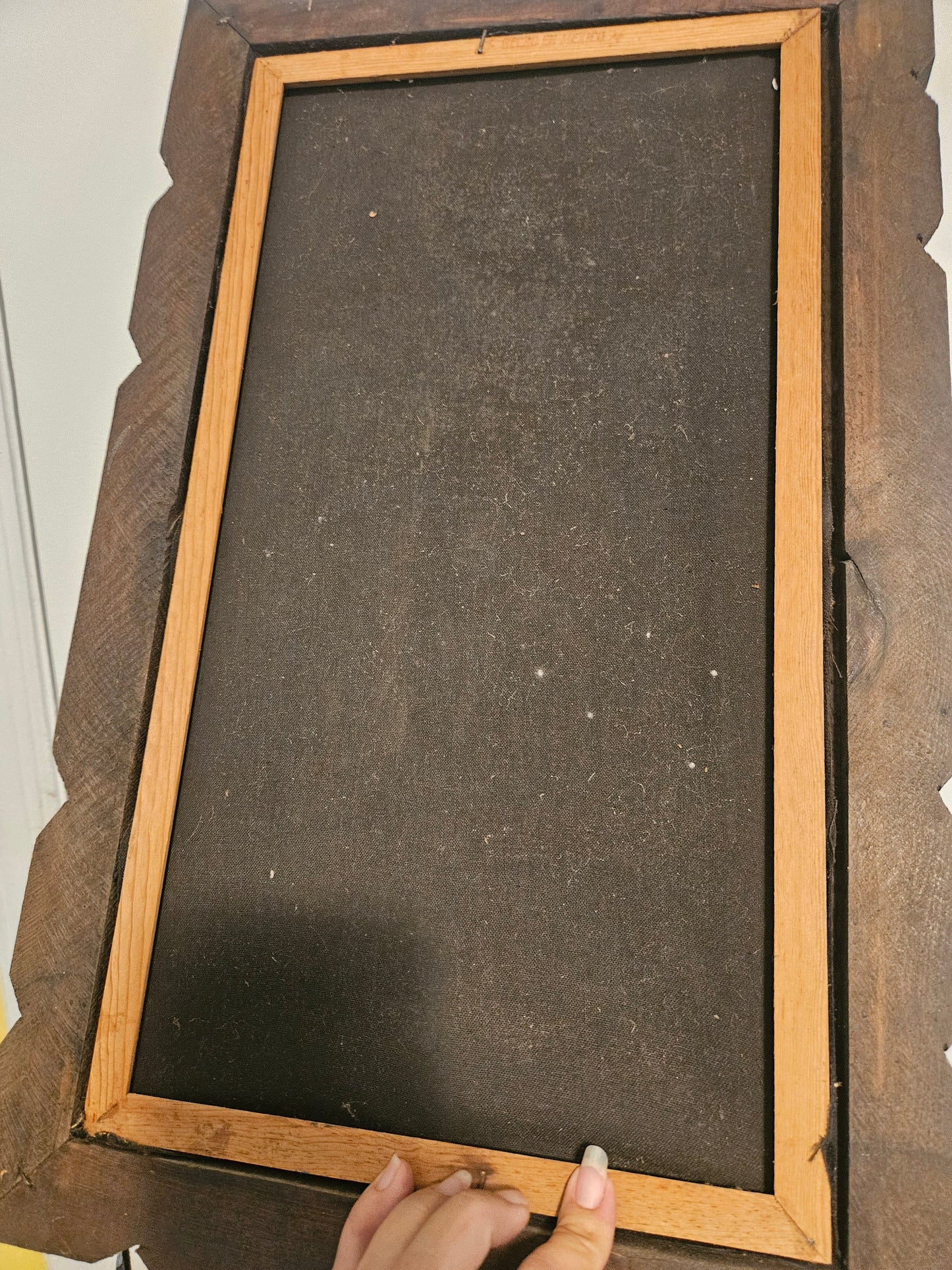 Back of velvet painting showing canvas backing and carved wood folk art frame construction