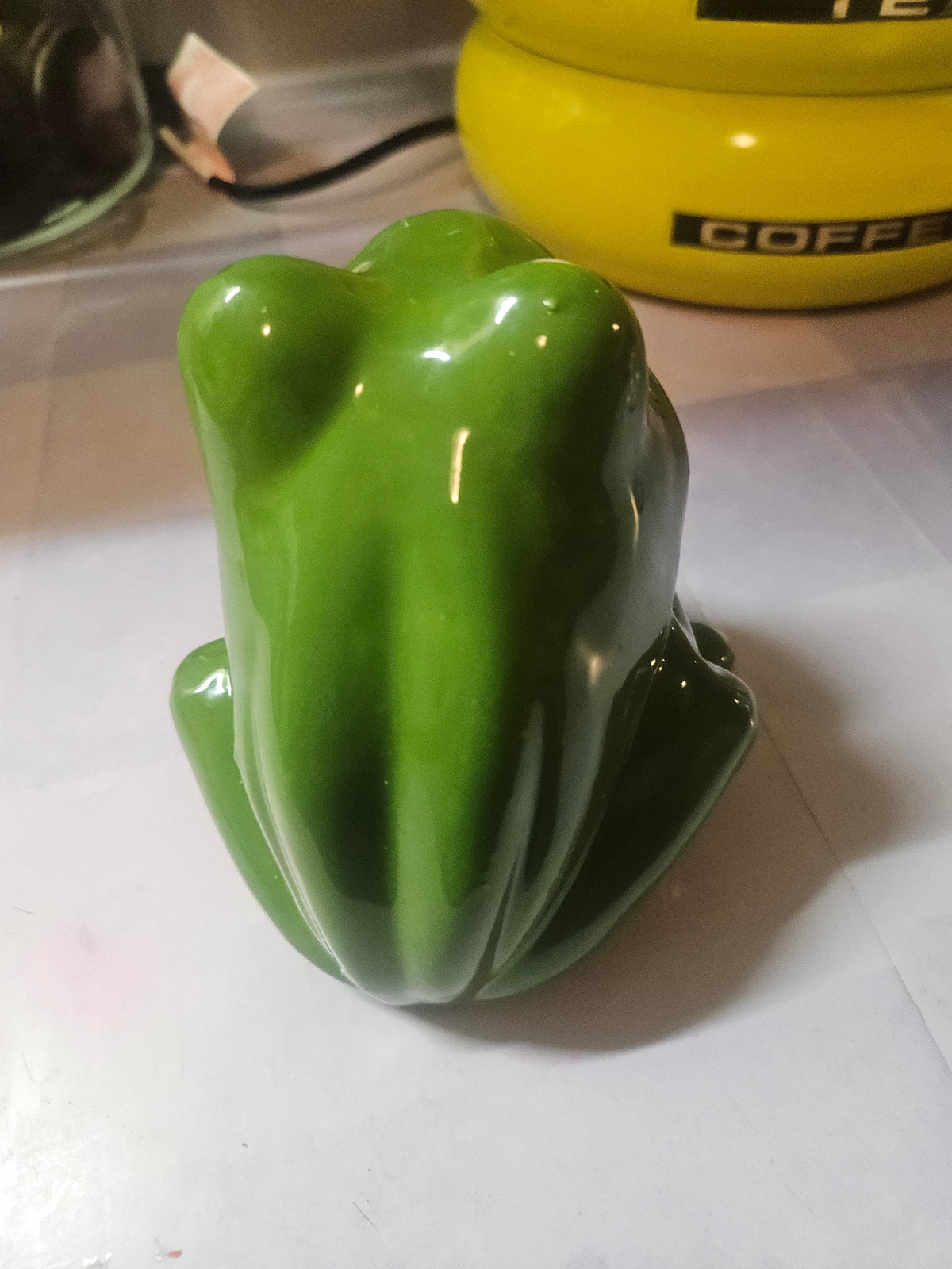 Ceramic sponge frog figurine facing forward with wide open mouth showing human-style teeth and blue eyes