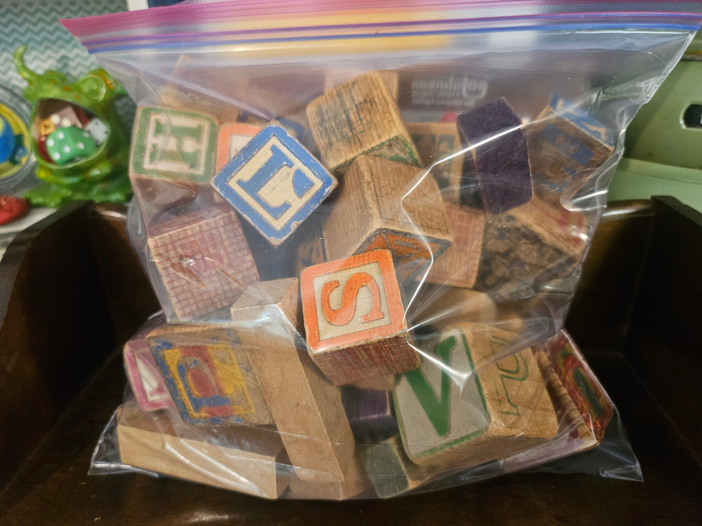 Front view of gallon Ziploc bag filled with vintage wooden alphabet and number blocks