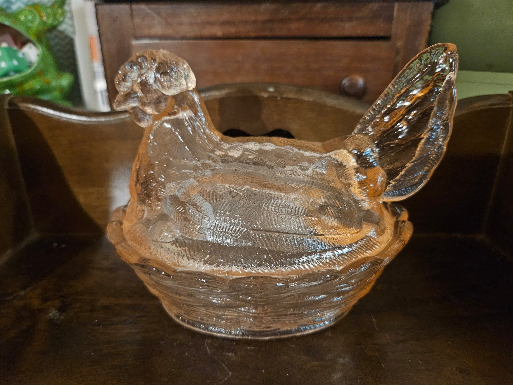 Modern clear pressed glass hen on a nest covered dish 5 inch showing detailed feather texture and basket weave base in natural light