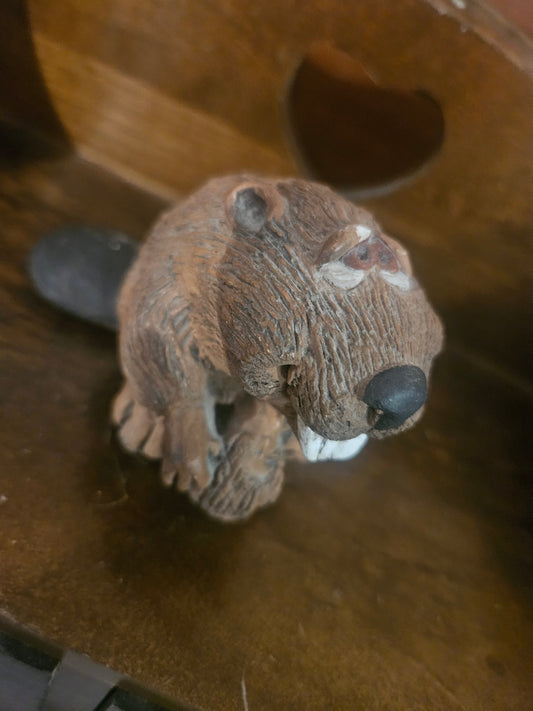 Vintage ceramic beaver figurine front view showing buck teeth, raised paws, and textured brown fur