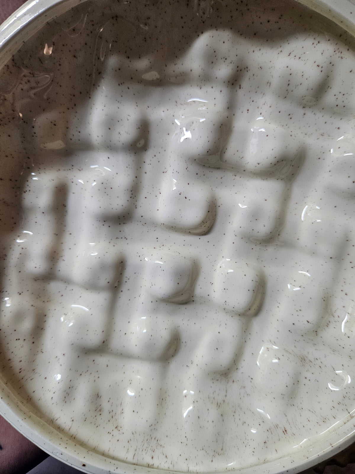 Interior view of ceramic pie keeper base from above showing warm golden speckled glaze