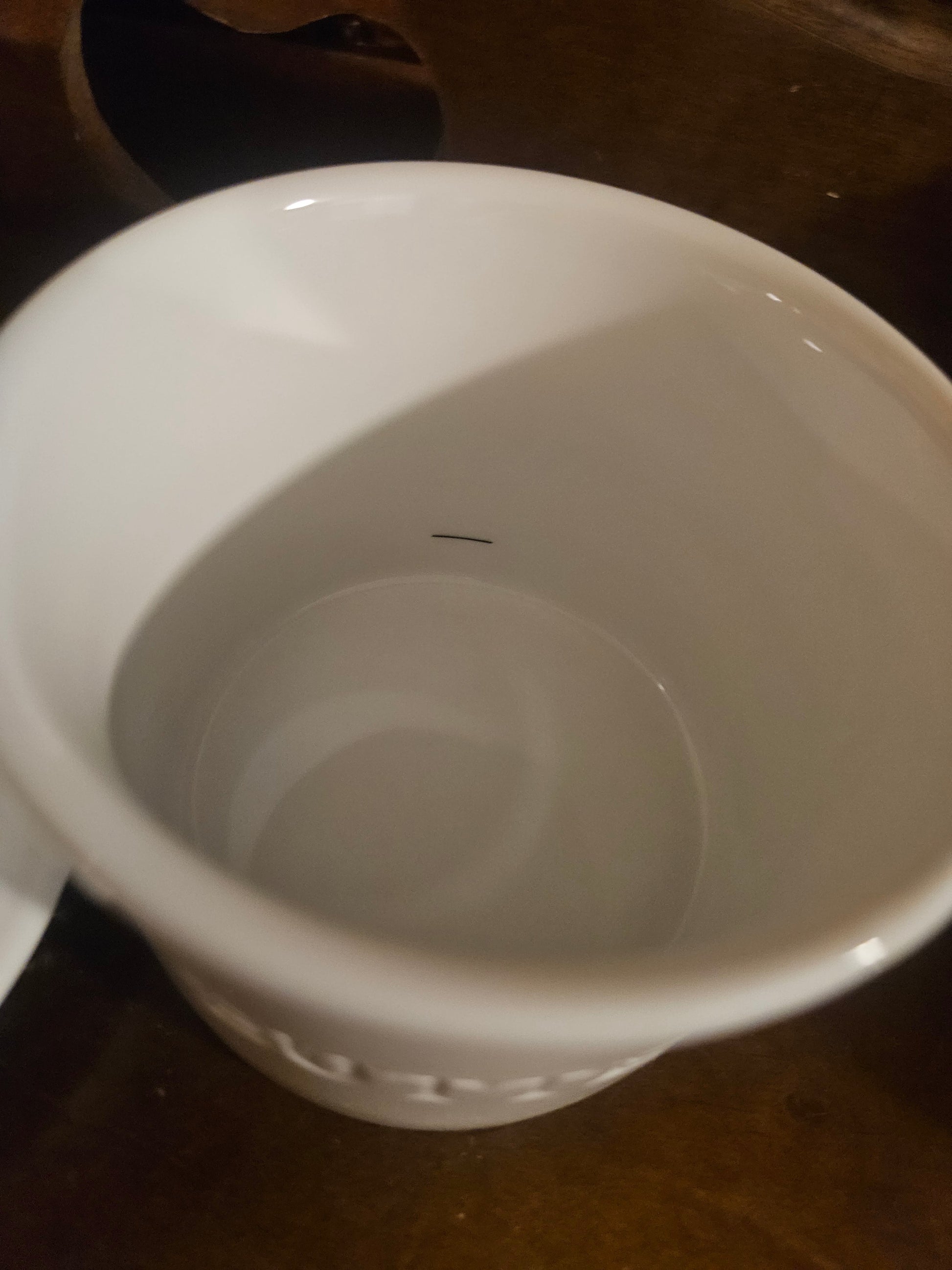 Interior of butter bell crock base showing small dark line mark on bottom