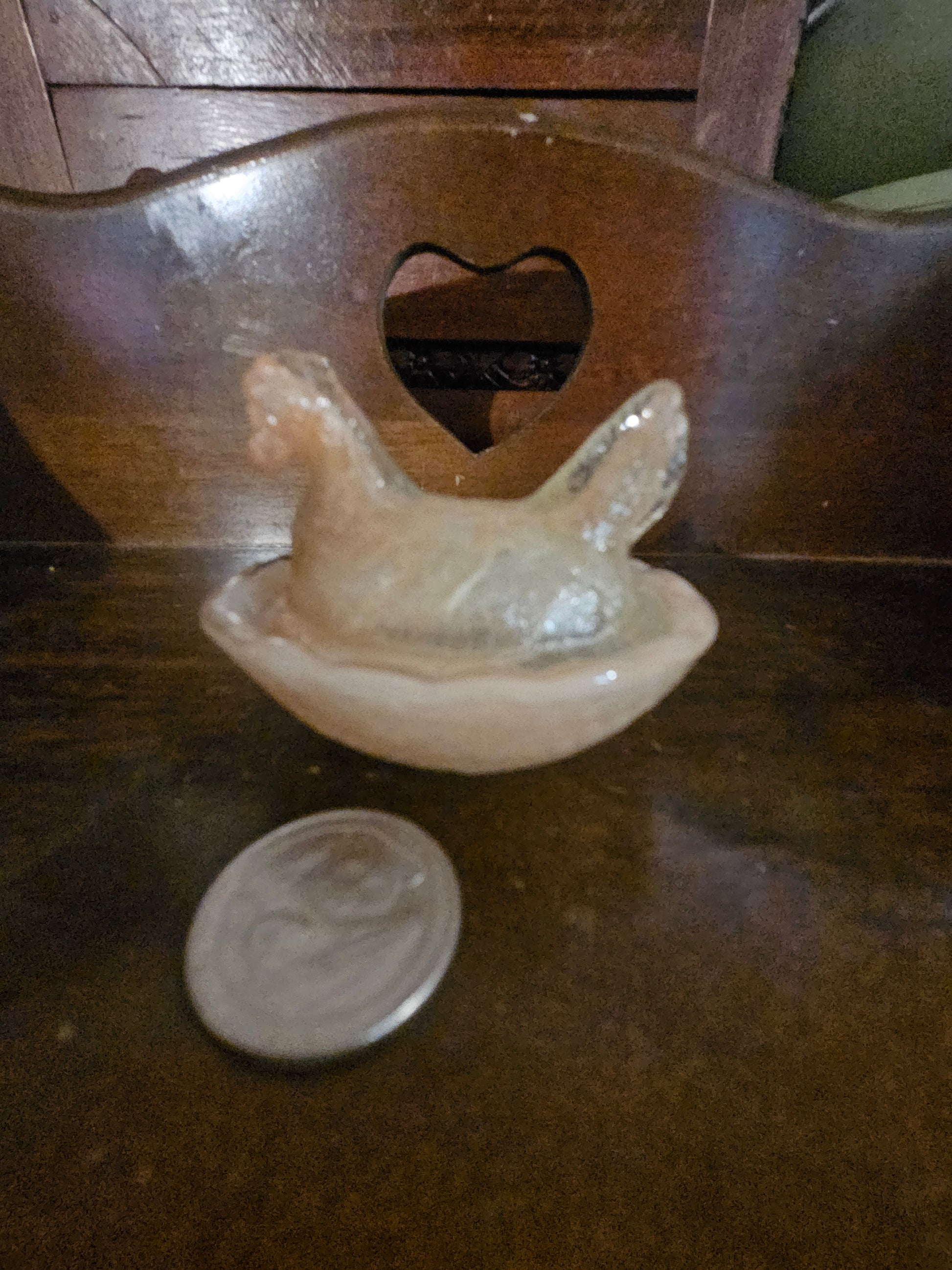 Modern pink opalescent glass hen on a nest covered dish with quarter for size reference