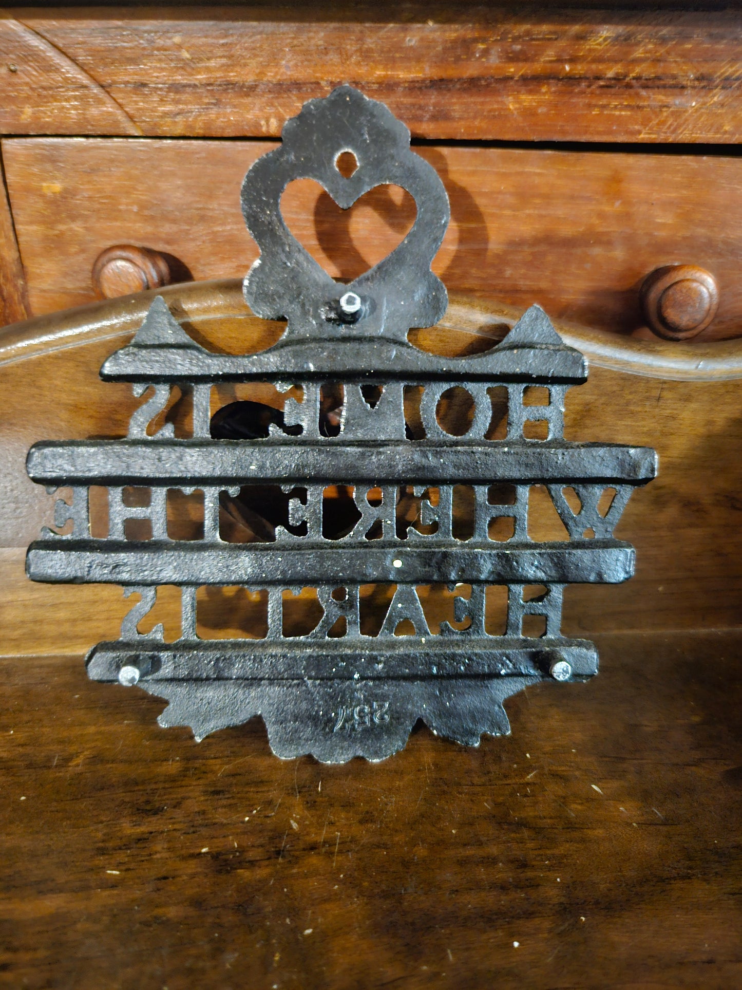 Back of cast iron Home Is Where the Heart Is plaque showing cast iron construction, bolt hardware, and mold number