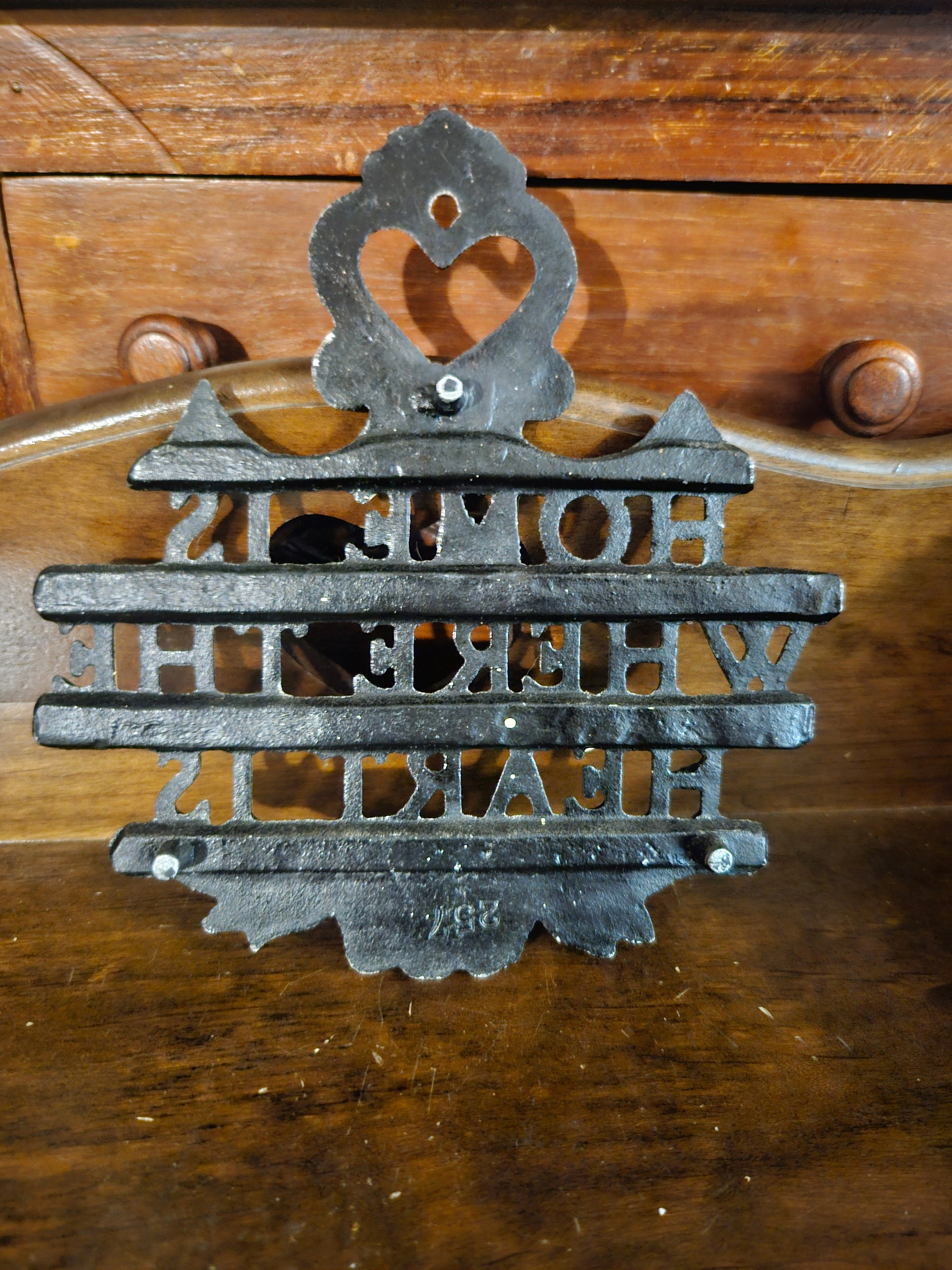 Back of cast iron Home Is Where the Heart Is plaque showing cast iron construction, bolt hardware, and mold number