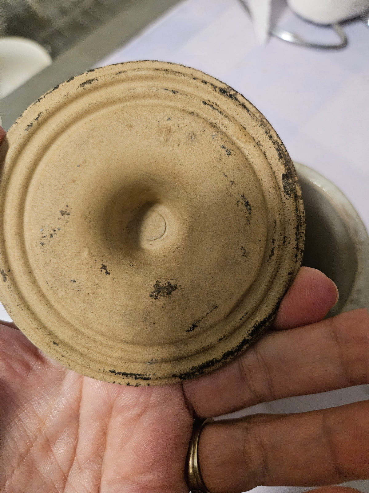 Underside of ceramic crock lid with staining and wear
