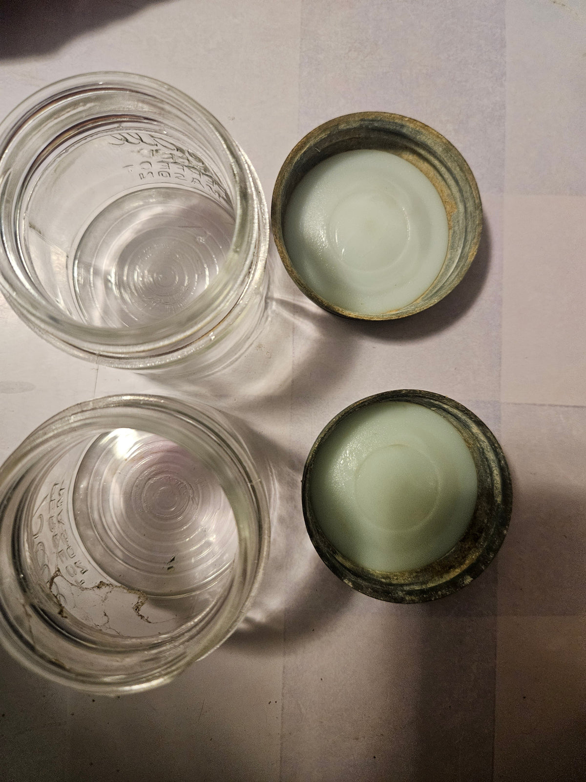 Top view of both aged zinc jar lids showing surface wear