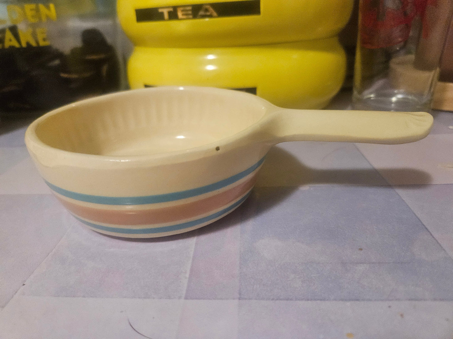 Vintage ceramic handled bowl with blue and pink stripes, side view