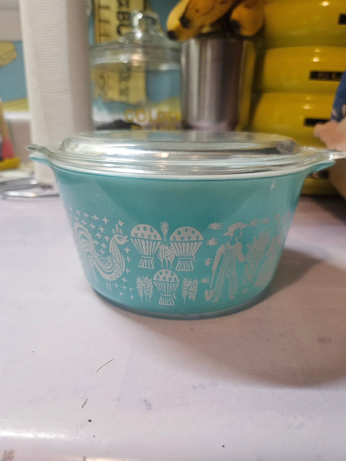 Vintage Pyrex Amish Butterprint no. 743 turquoise round casserole with white Amish man and woman, rooster, and wheat sheaves print, with clear glass lid