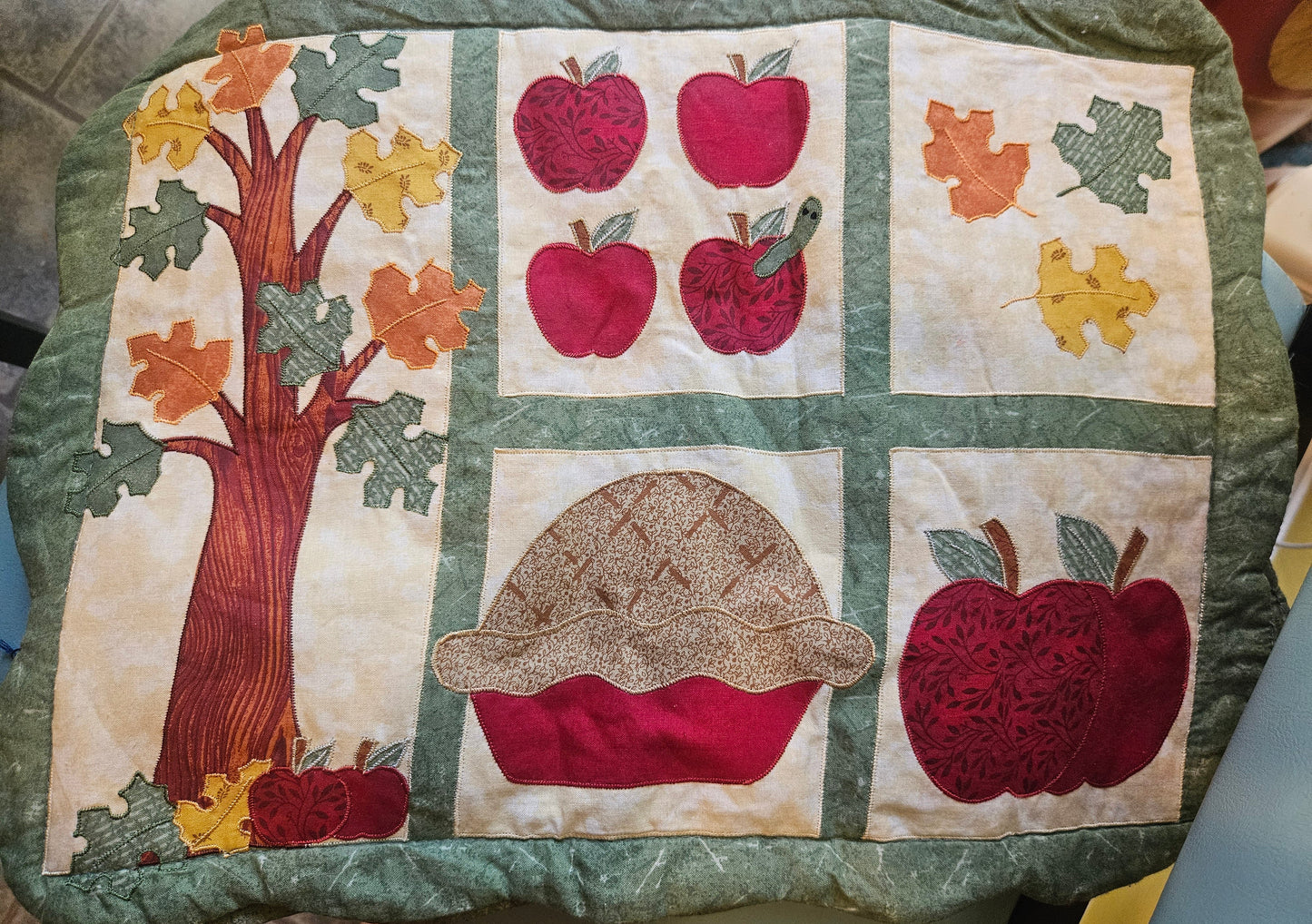 Set of 4 vintage quilted fall harvest applique placemats showing apples, acorn, autumn leaves and tree on cream background with sage green border