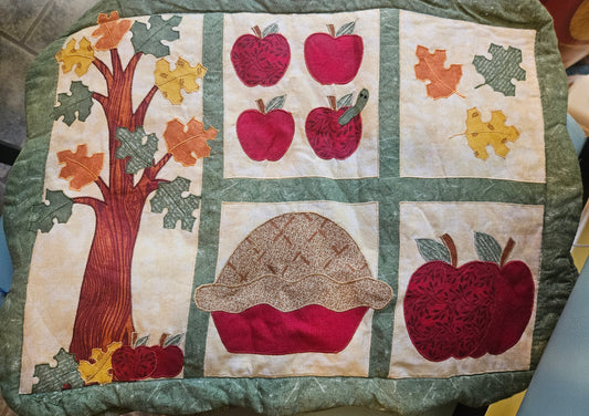 Set of 4 vintage quilted fall harvest applique placemats showing apples, acorn, autumn leaves and tree on cream background with sage green border