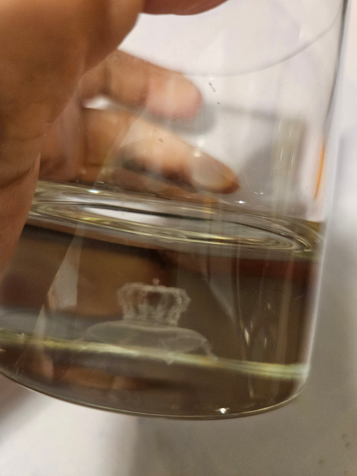 Close view of crown-and-crab motif near the base of the glass