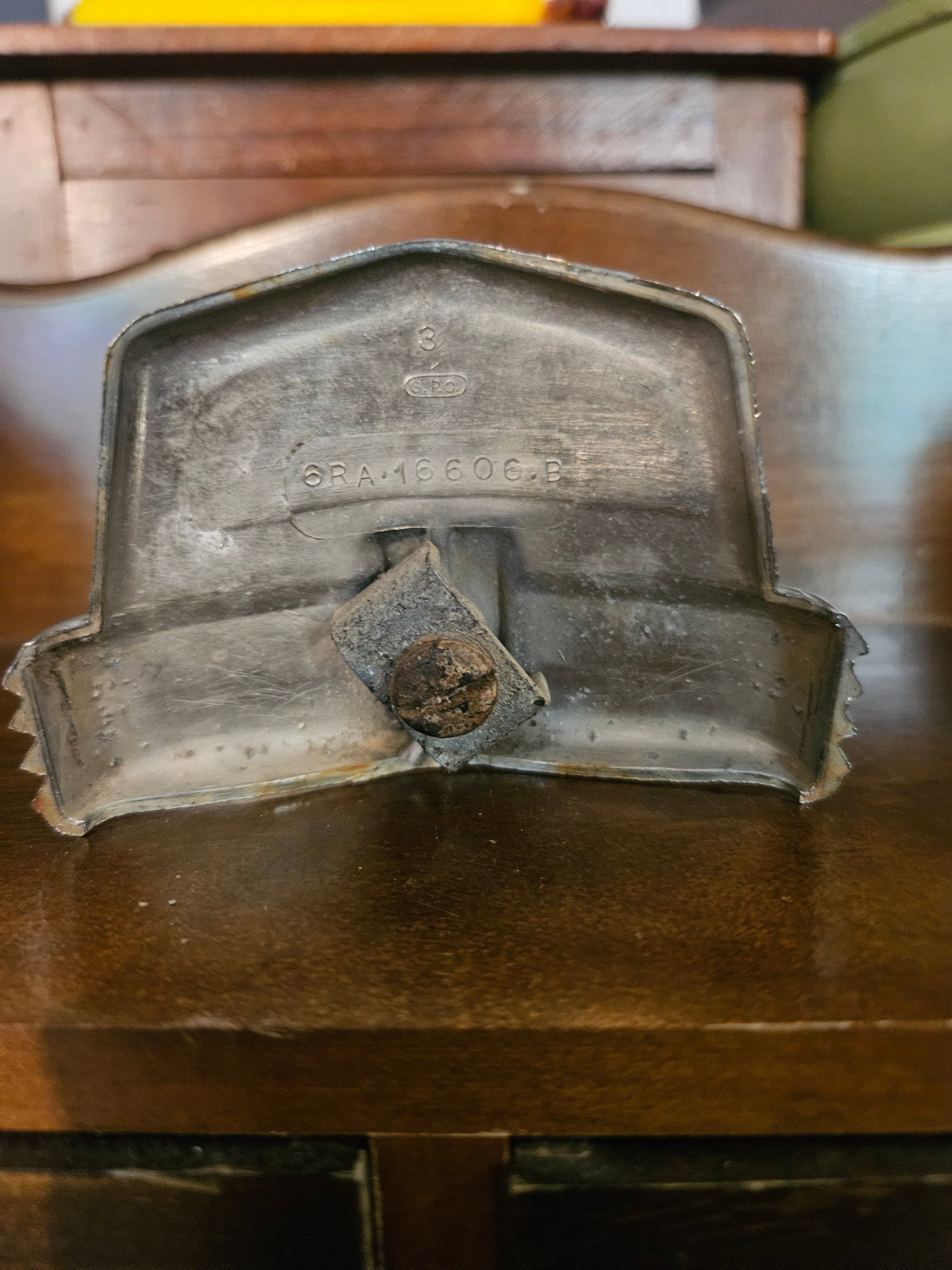 Back of 1946 Ford Super Deluxe 8 emblem showing part number 6RA-16606-B and mounting hardware