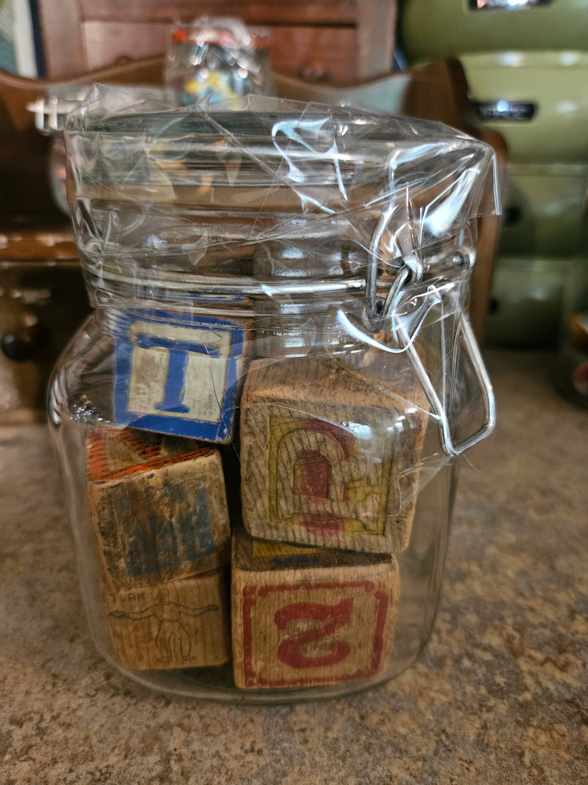 Swing-top glass jar filled with vintage wooden alphabet blocks, closed view