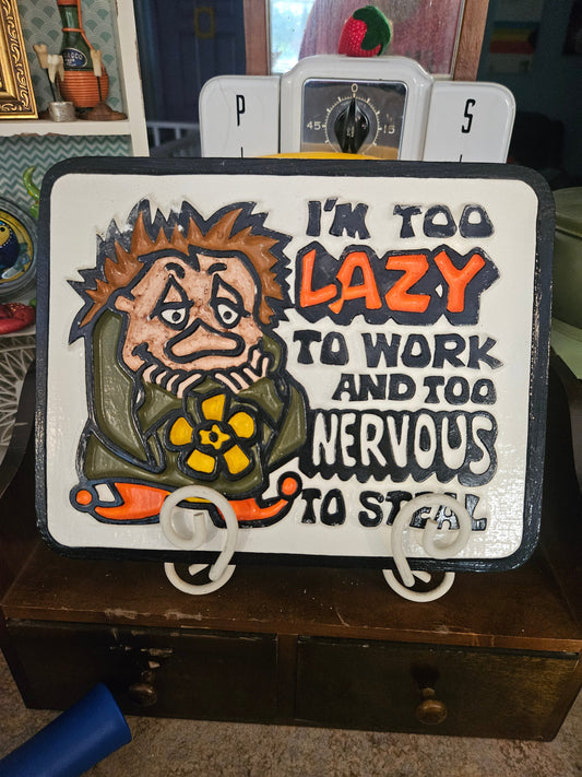 Front of vintage ceramic wall plaque reading I'm Too Lazy to Work and Too Nervous to Steal with grumpy cartoon character