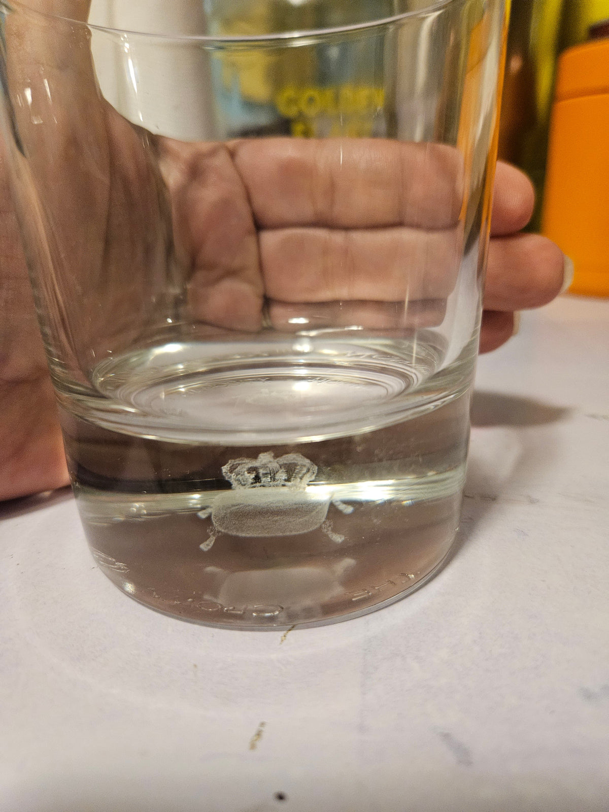 Clear tumbler with thick base and small crown-and-crab motif