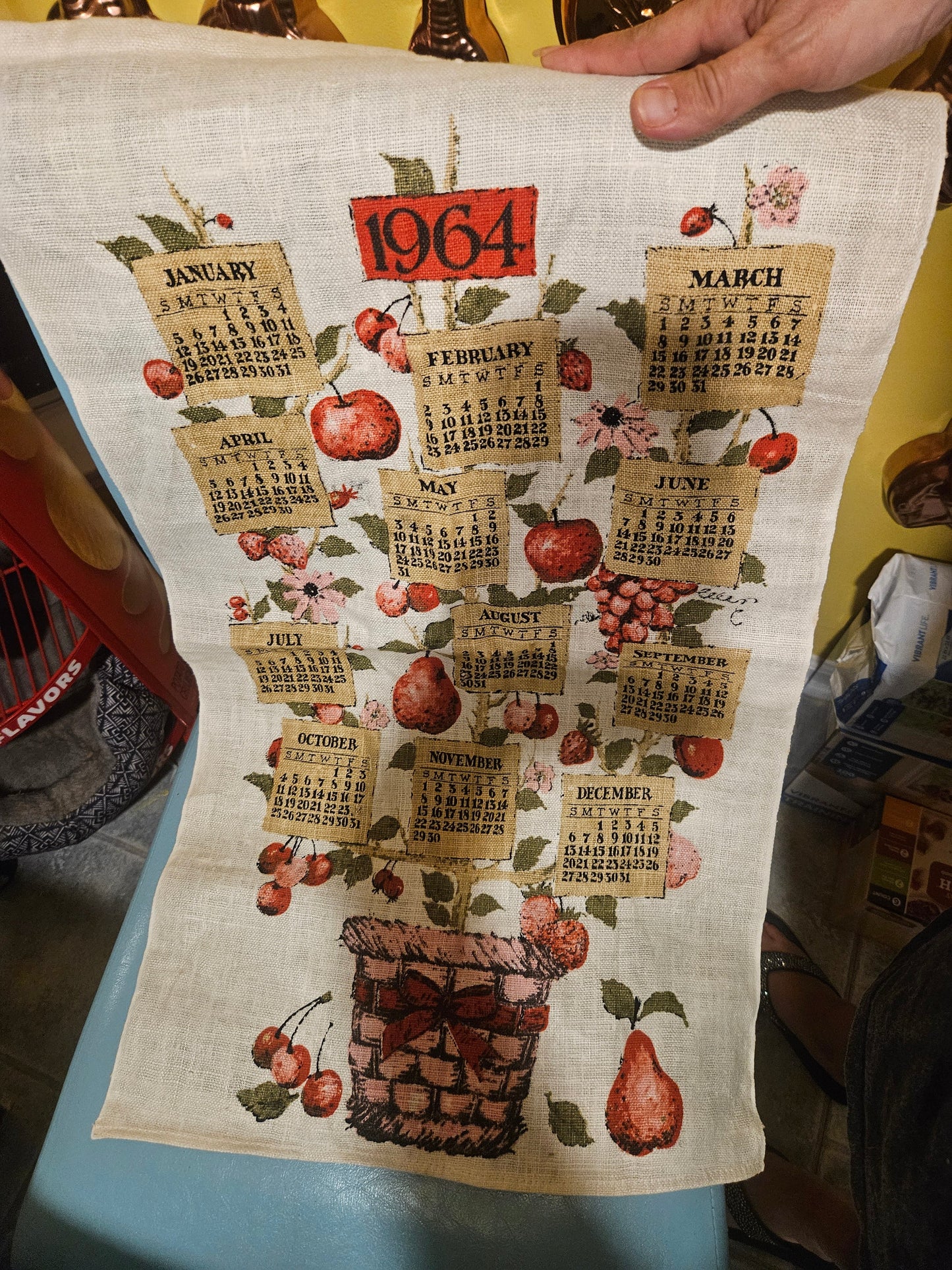 1964 fruit basket calendar tea towel showing novelty burlap-tag month design on fruit tree growing from wicker basket