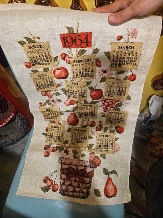 1964 fruit basket calendar tea towel showing novelty burlap-tag month design on fruit tree growing from wicker basket