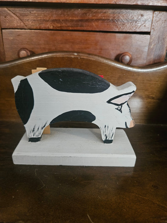 Handmade folk art wooden pig recipe card holder, side view showing black and white paint and base