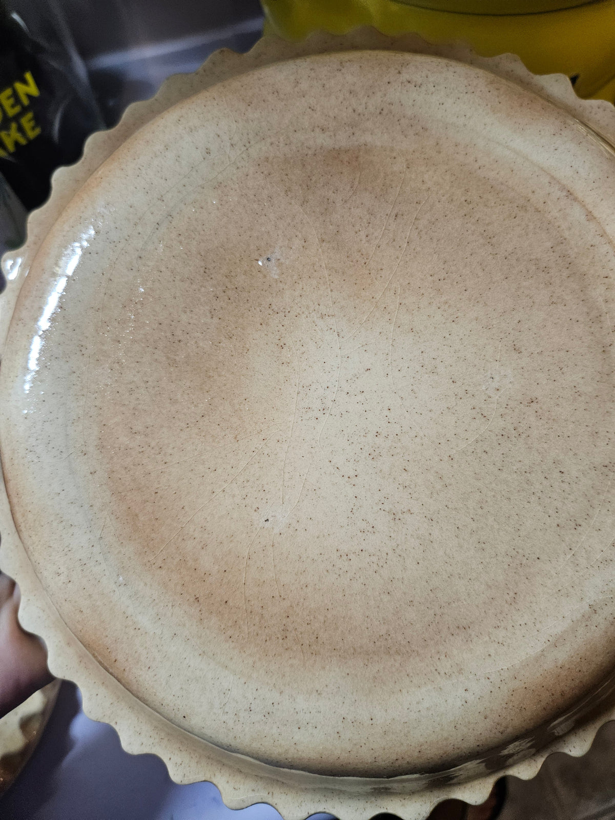 Interior underside of pie keeper lid showing raised white lattice pattern in speckled glaze