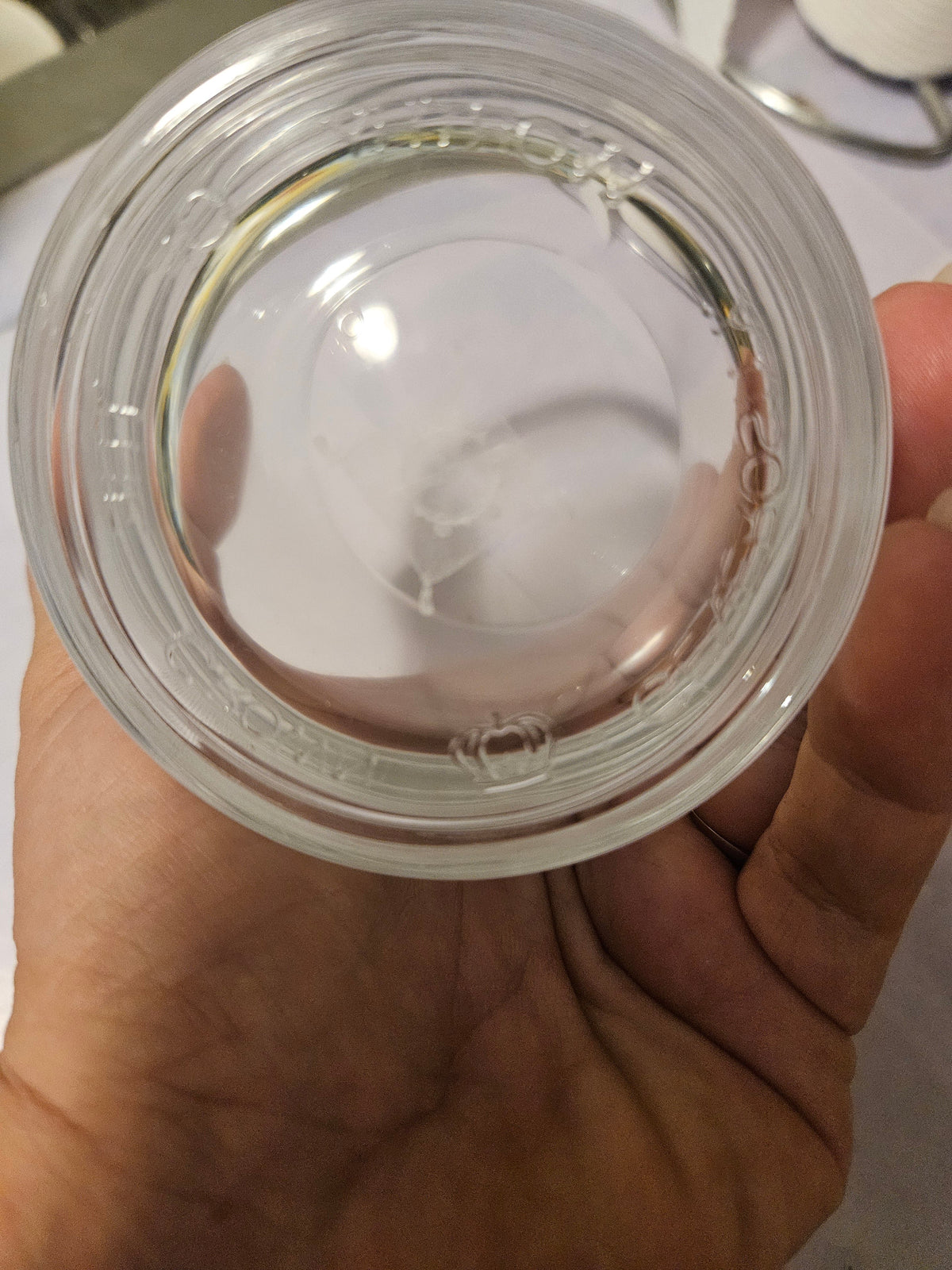 Underside of clear glass tumbler showing thick circular base