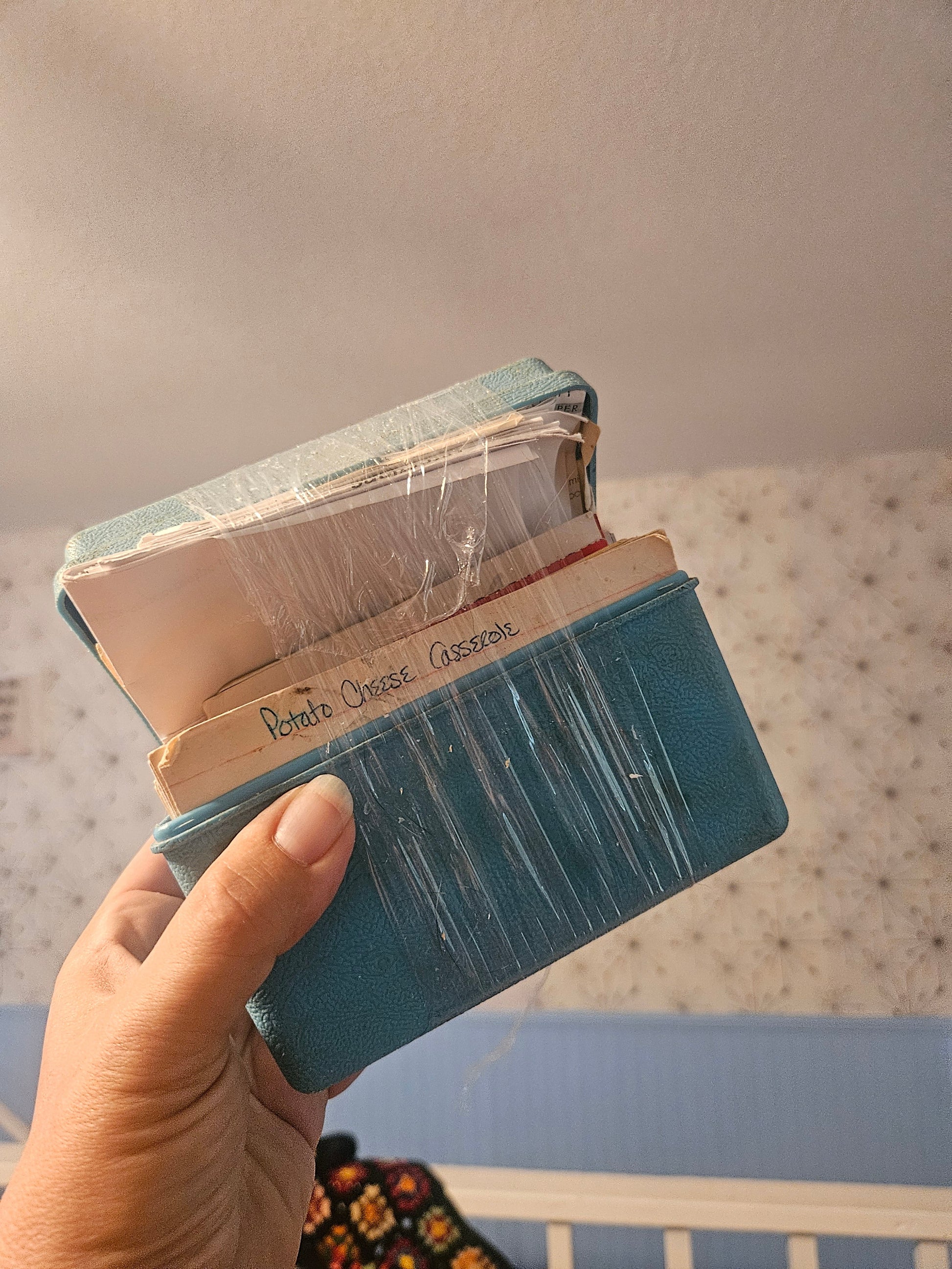 Vintage teal blue recipe box held open showing recipe cards inside
