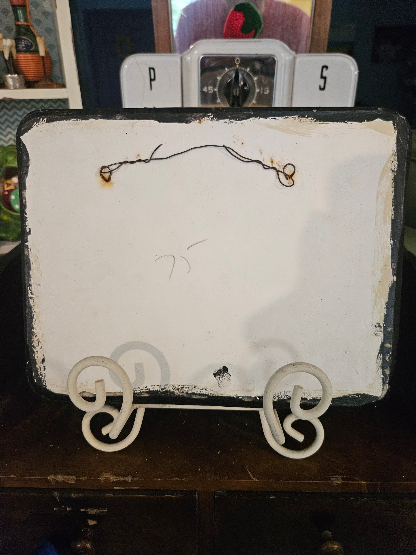 Back of vintage ceramic golf plaque showing wire hanger, handwritten price mark, and paint wear on reverse