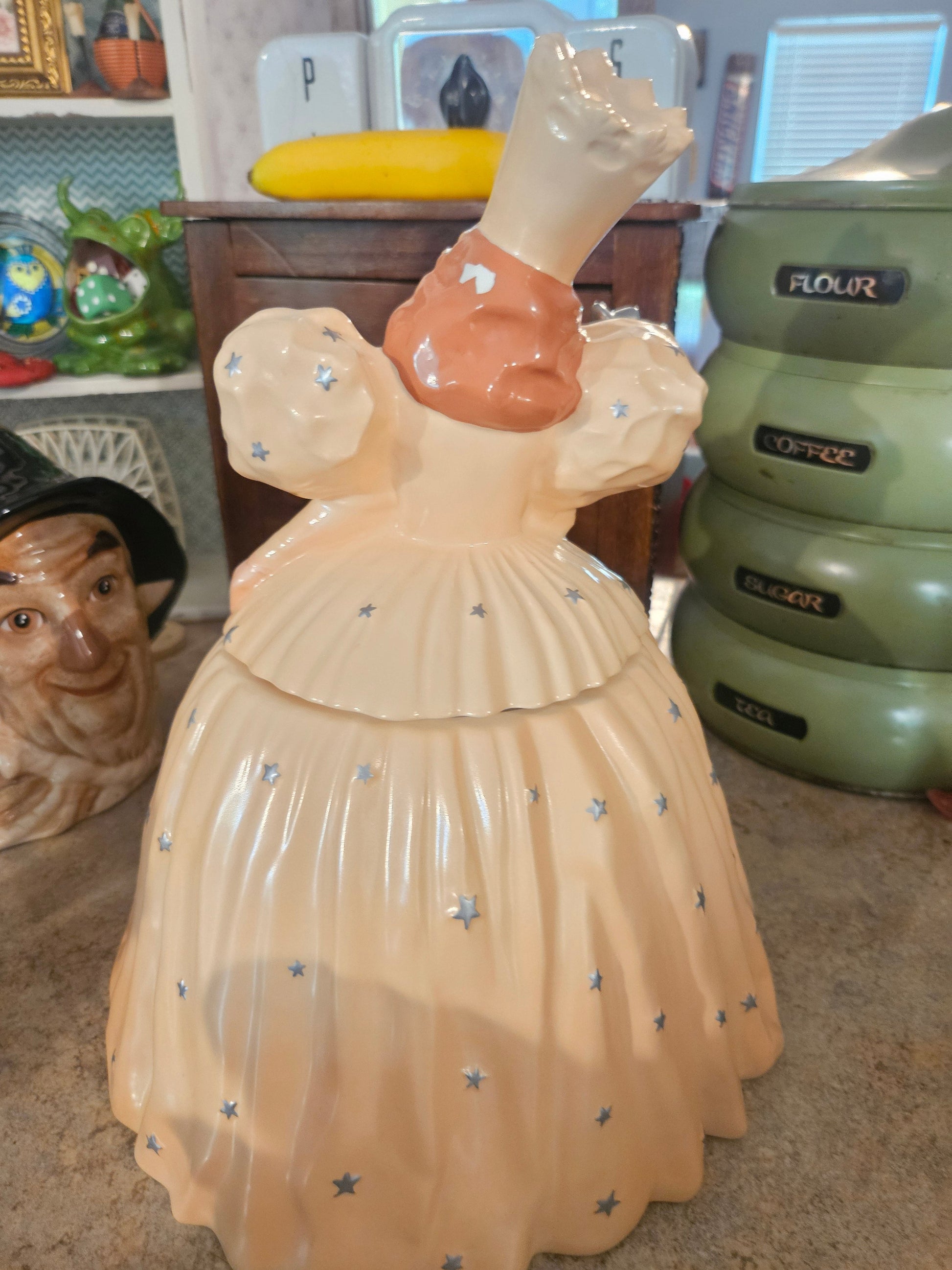 Back view of Glinda cookie jar showing removable lid and star-accented gown