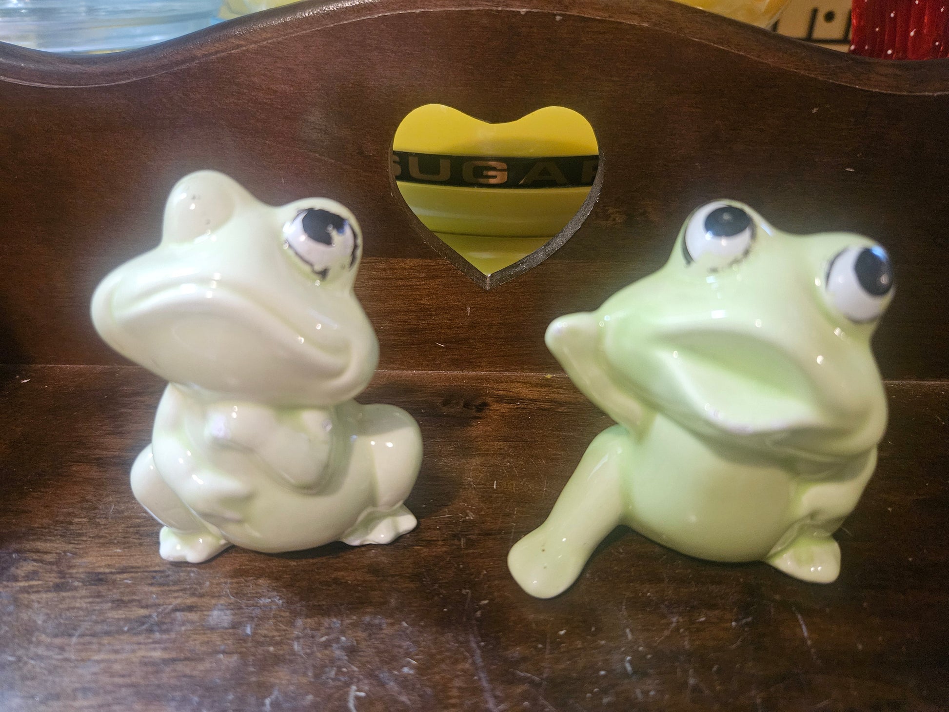 Vintage ceramic frog salt and pepper shakers front view — white and mint green with big eyes