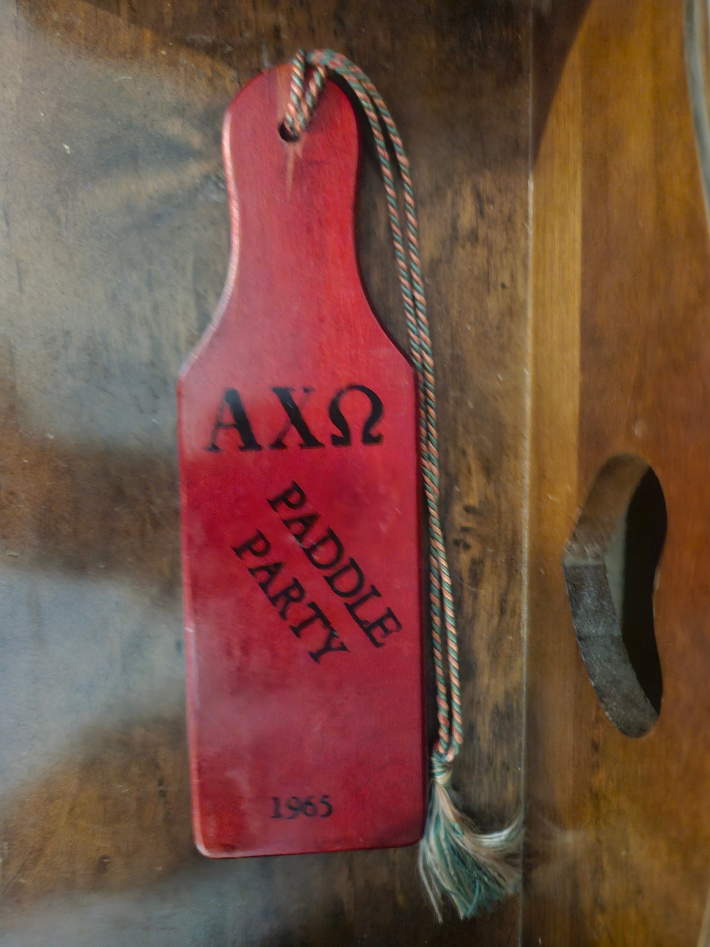 Vintage Alpha Chi Omega sorority paddle front showing AXO Paddle Party 1965 in black lettering on red wood