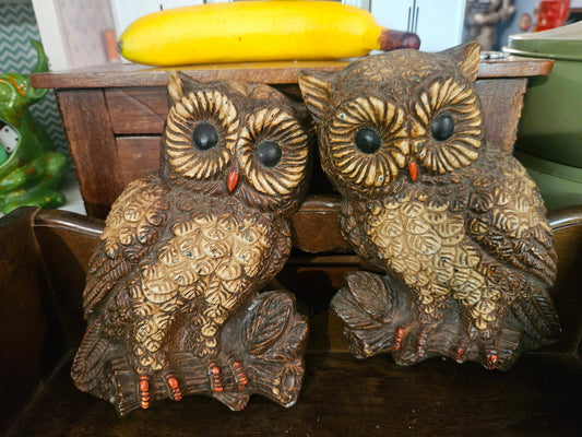 Pair of vintage 1970s chalkware owl wall hangings front view showing textured brown feathers and black dome eyes