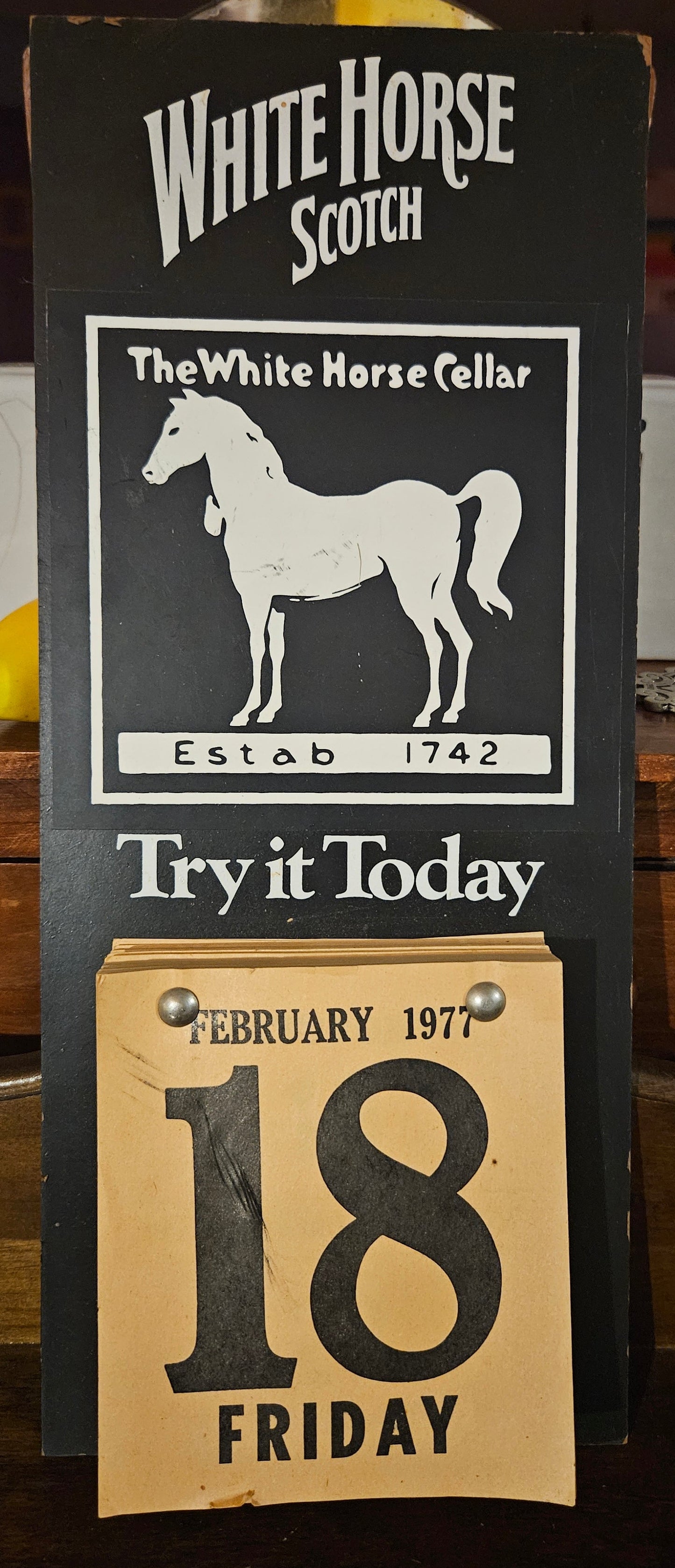 White Horse Scotch Advertising Calendar Sign – February 1977