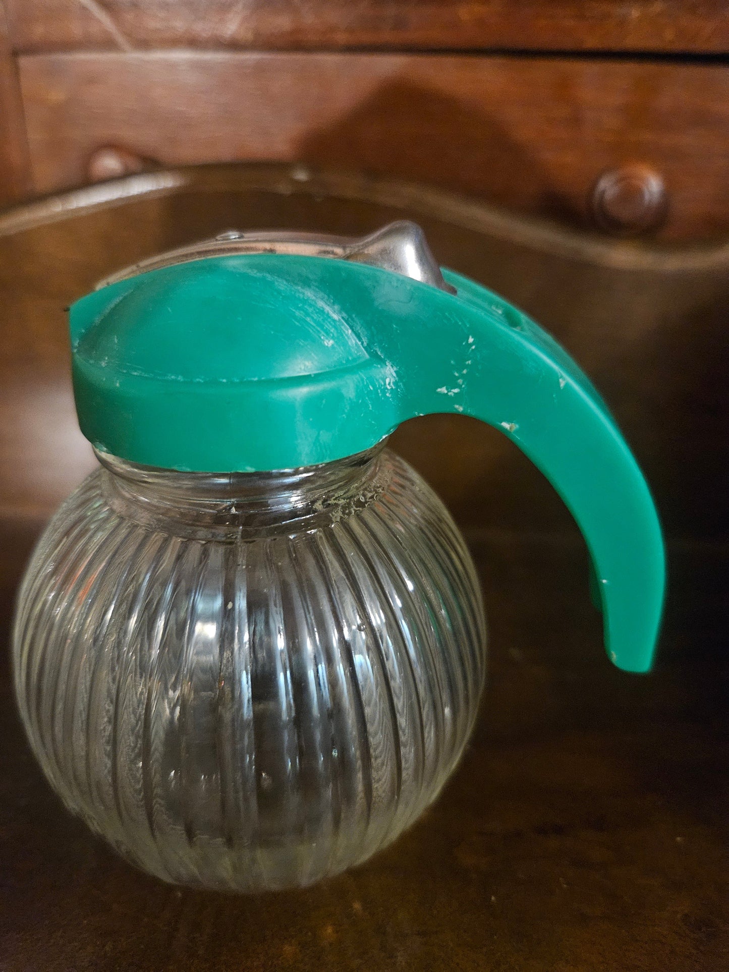 Close-up of teal turquoise flip-top lid showing surface crazing and wear on plastic