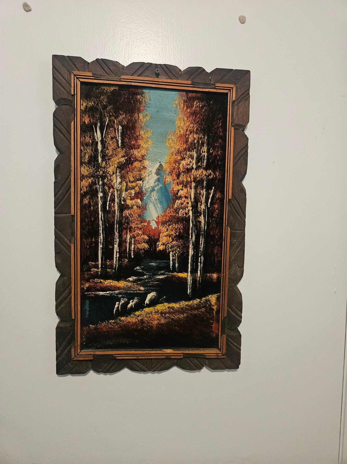 Vintage velvet painting of autumn birch forest with sheep at stream in carved dark wood folk art frame