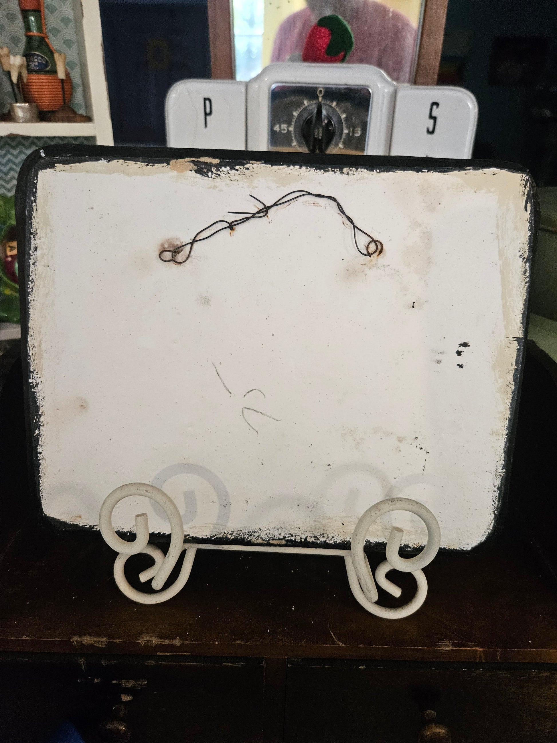 Back of vintage ceramic hunting plaque showing wire hanger, pencil mark, and paint wear on reverse