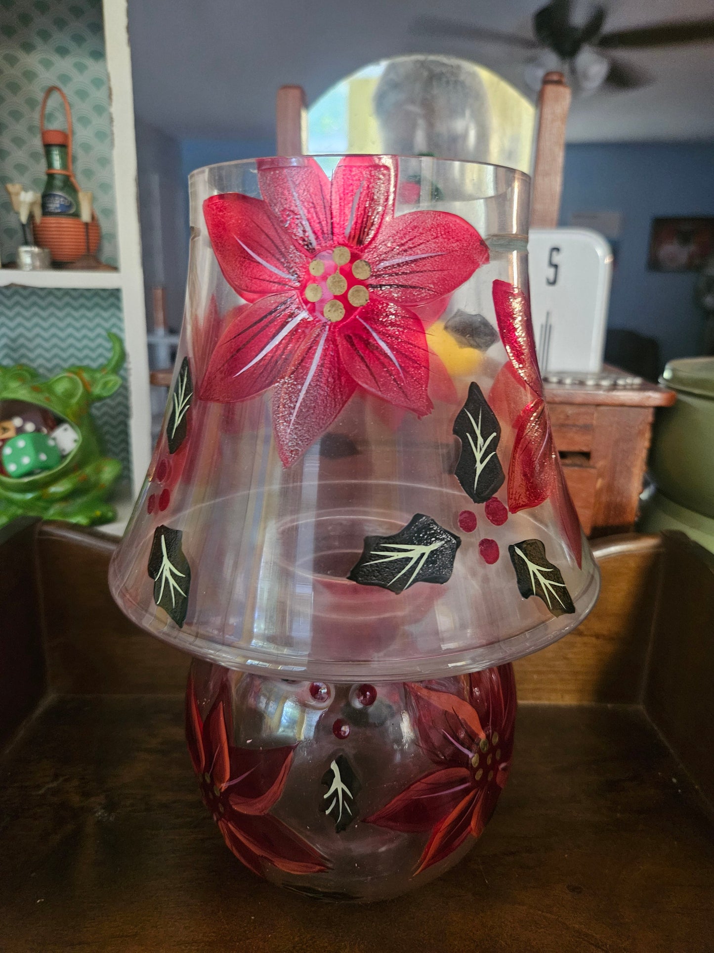 Underside of glass shade showing hand-painted poinsettia and holly pattern from below