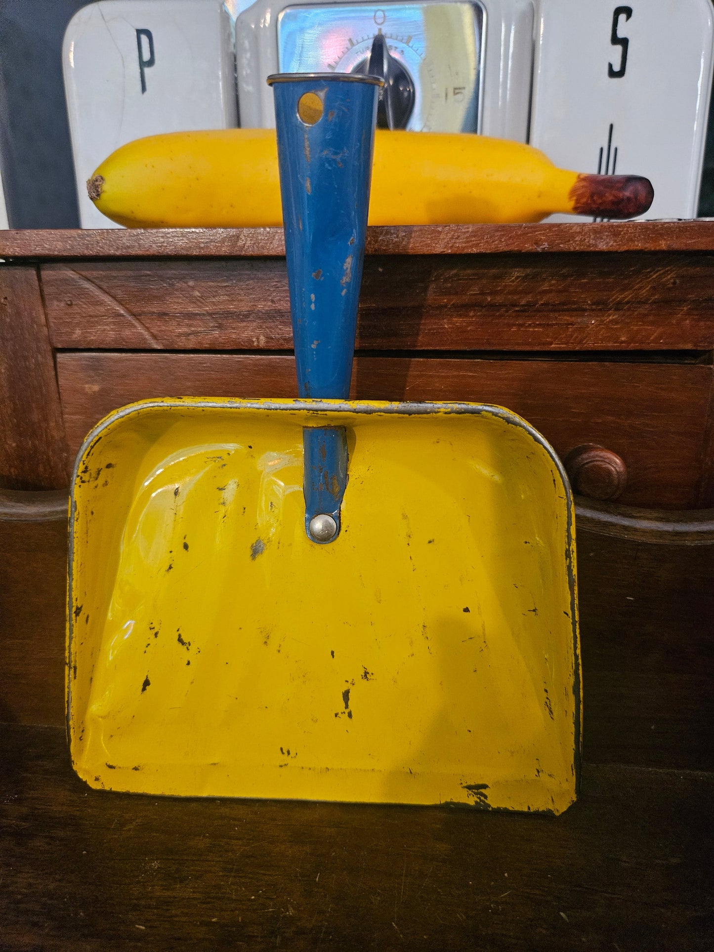 Vintage mini tin dustpan front view showing yellow interior and cobalt blue handle with chippy paint