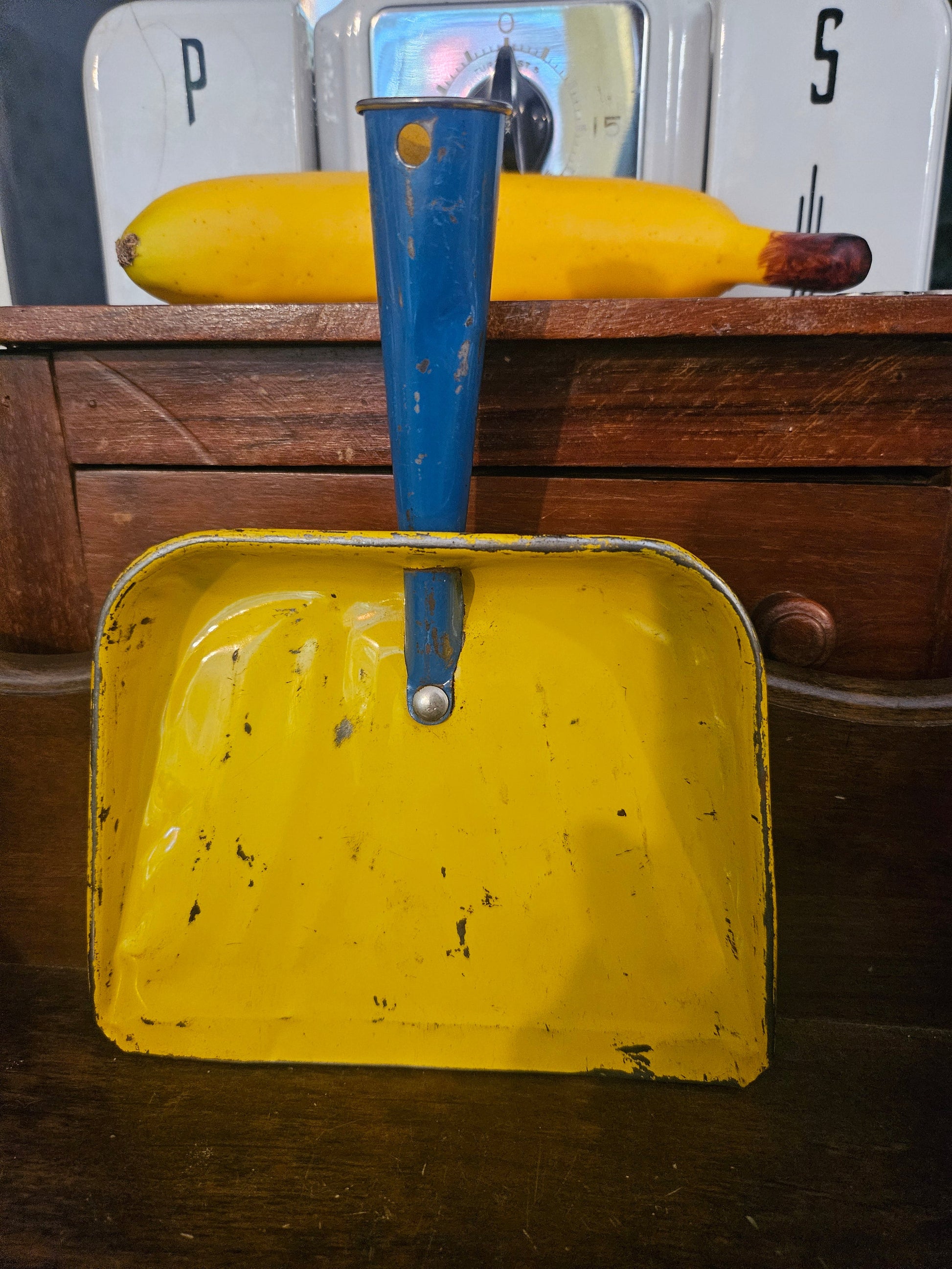 Vintage mini tin dustpan front view showing yellow interior and cobalt blue handle with chippy paint