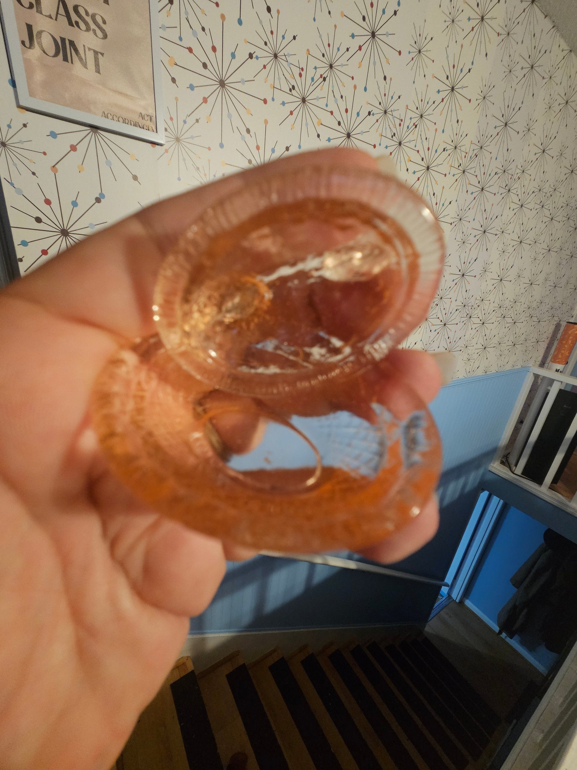 Inside of iridescent carnival glass hen on nest base showing residue and wire detail