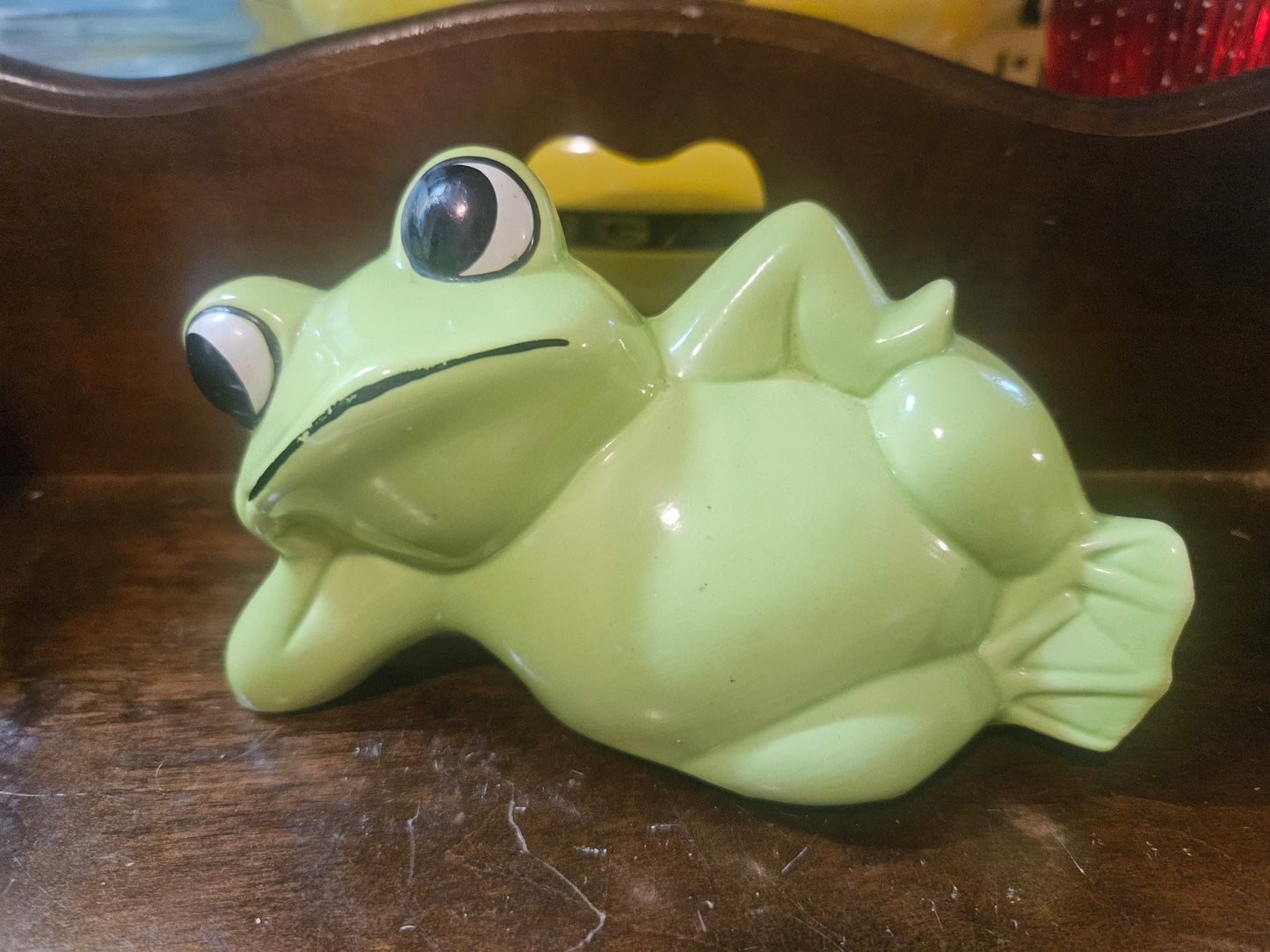 Vintage mint green ceramic lounging frog coin bank, front view showing big eyes and reclining pose