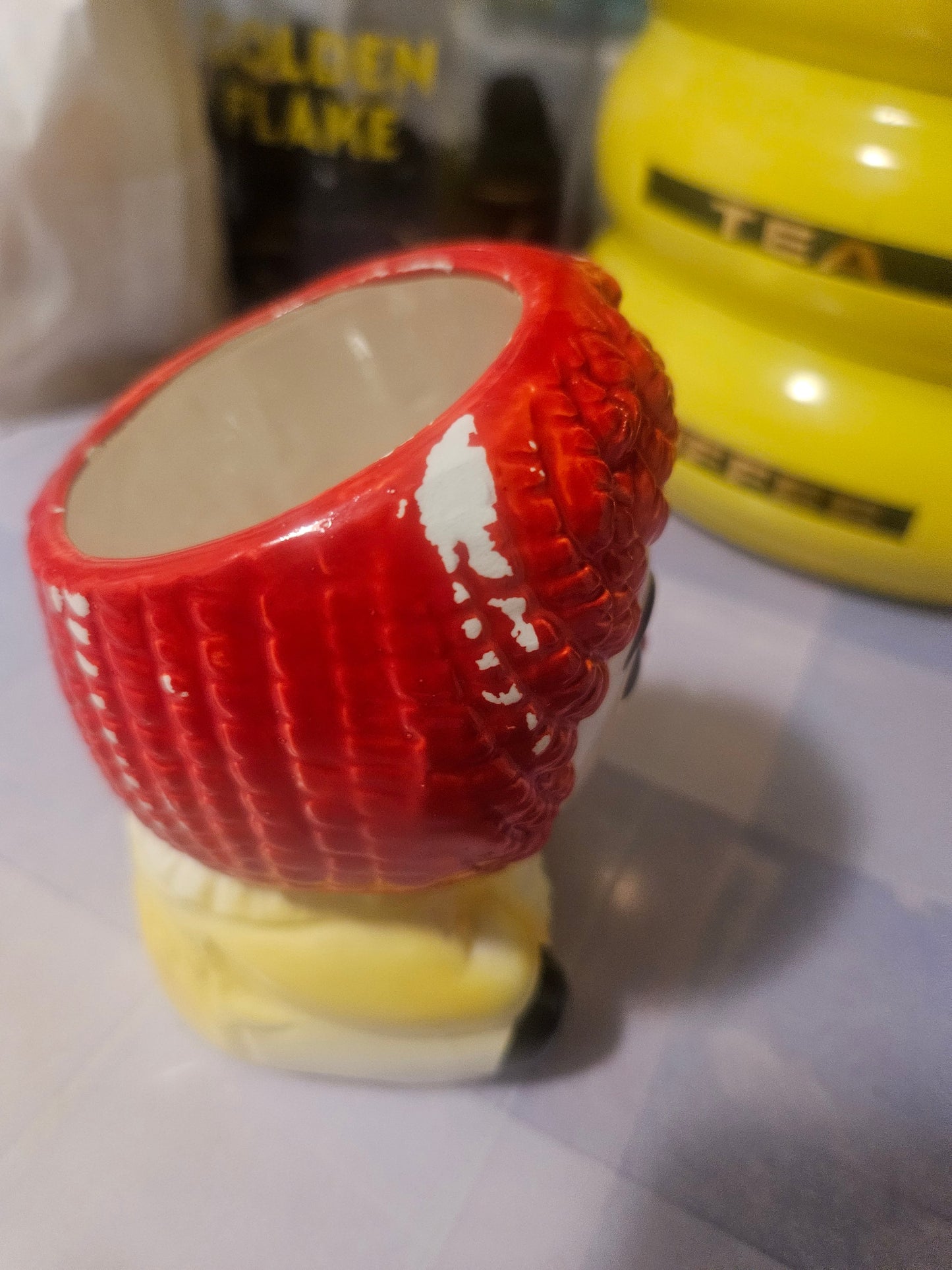 Vintage Raggedy Ann ceramic planter angled view showing paint loss on red hair cap