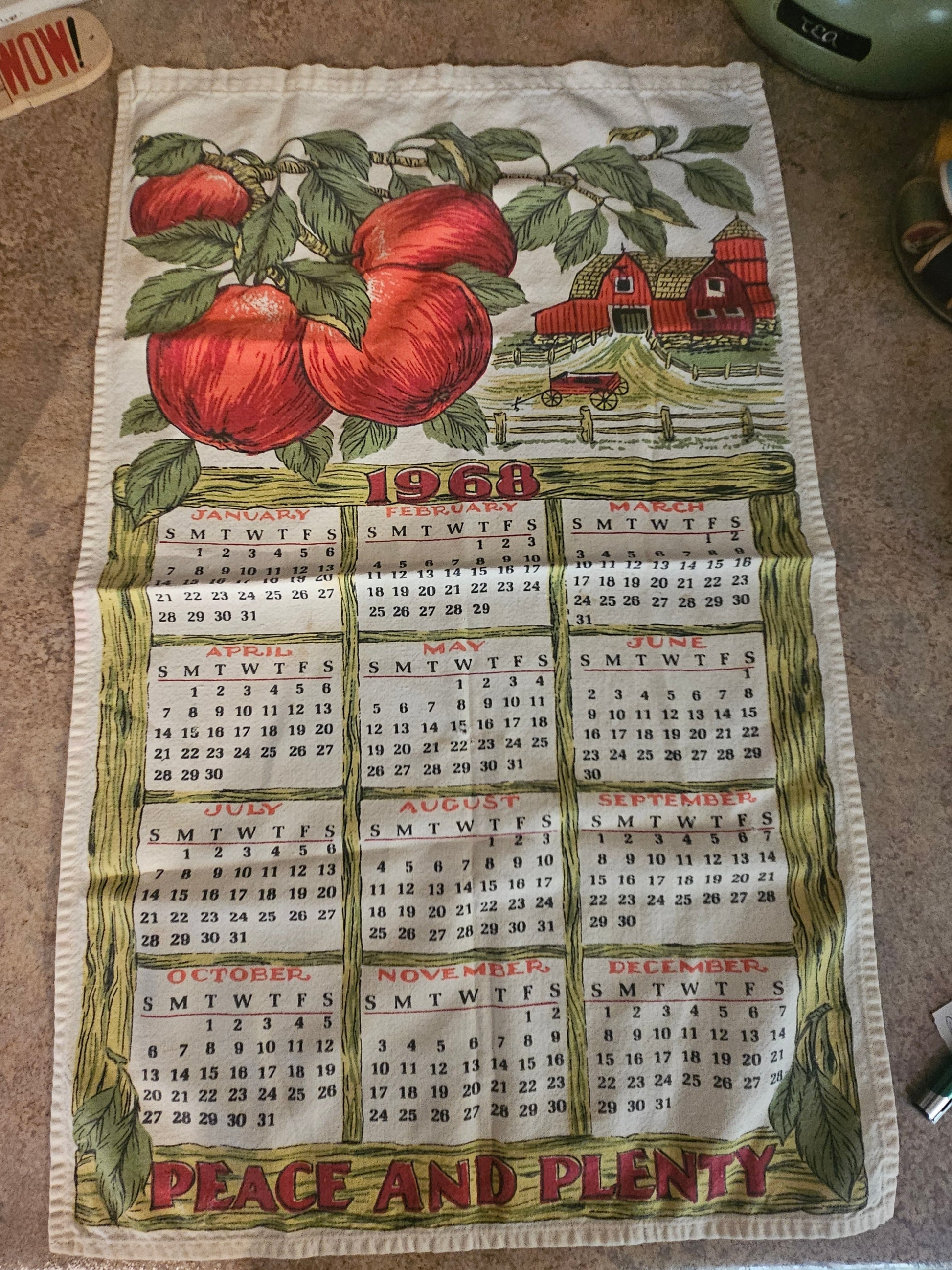 1968 Peace and Plenty calendar tea towel showing full farm scene with red apples, barn, and tractor