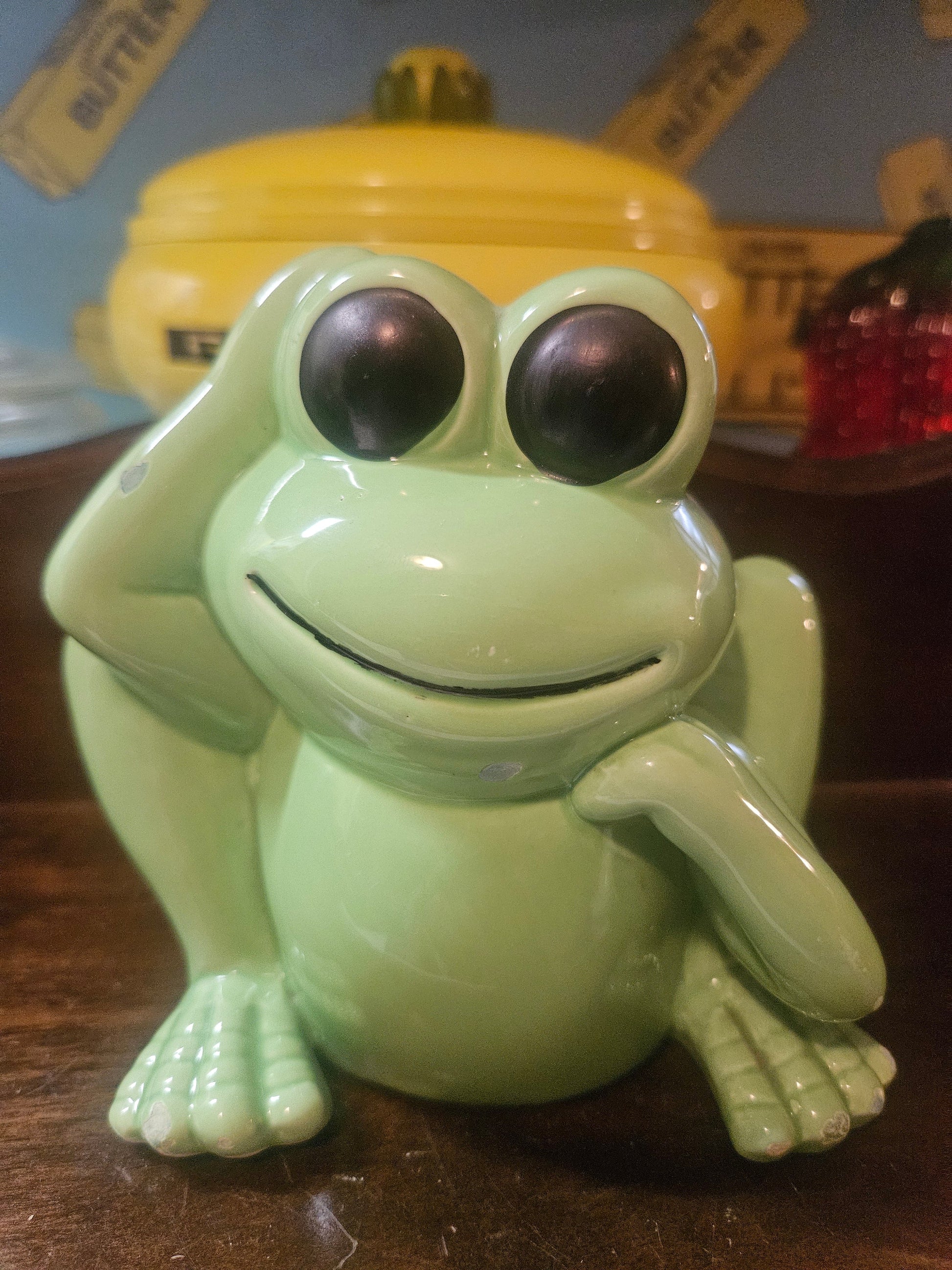 Vintage mint green ceramic frog coin bank, front view showing big eyes and smiling face
