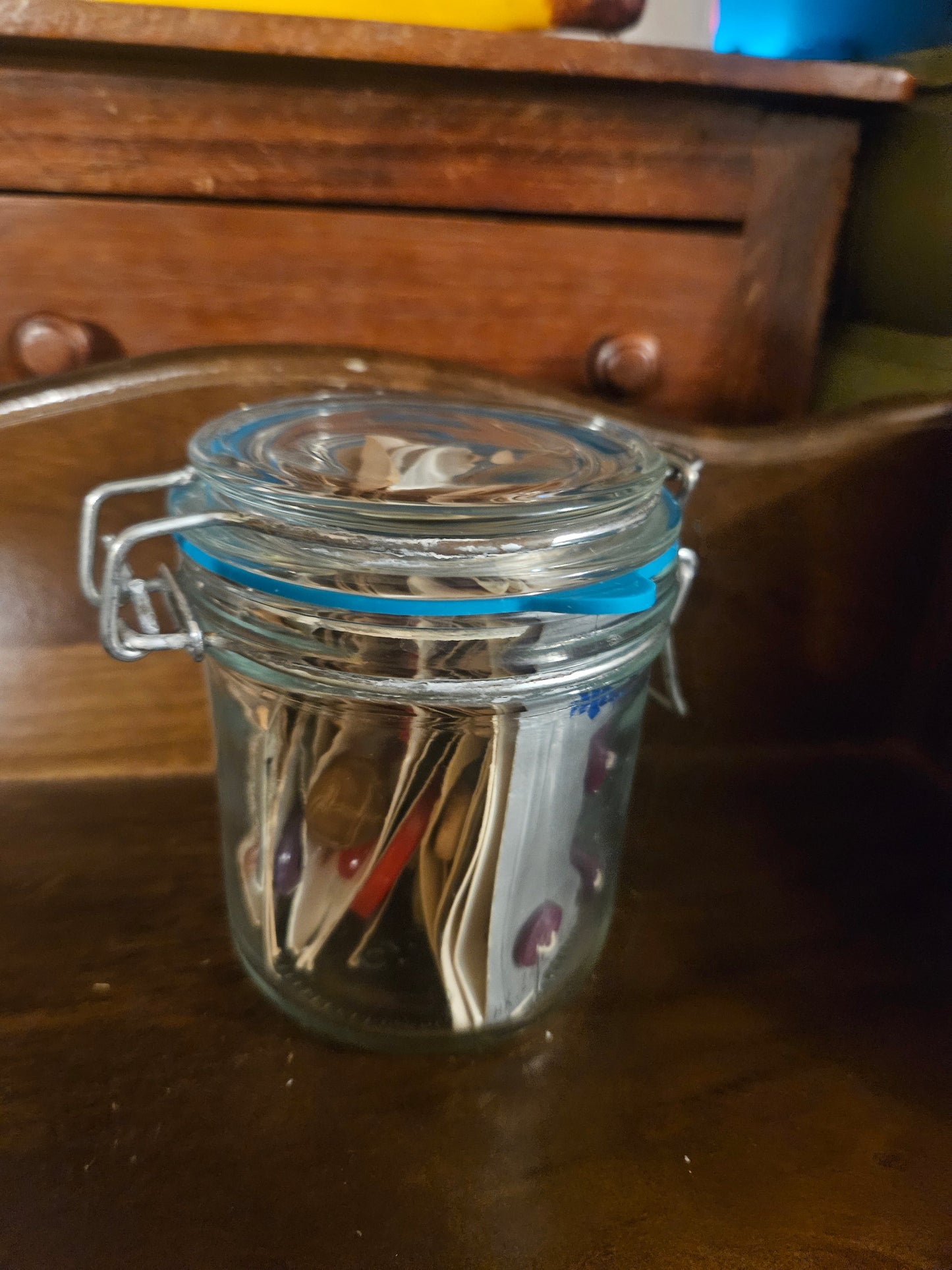 Swing-top glass jar filled with vintage button cards, closed view